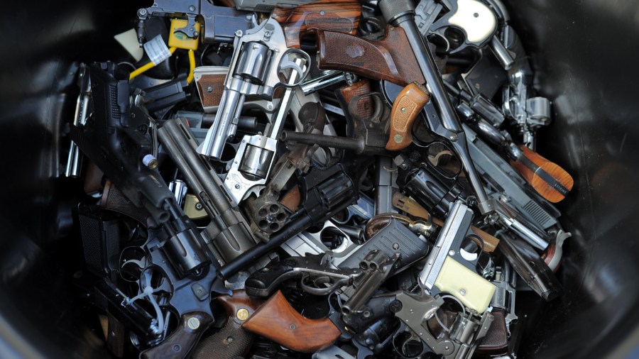 A trash bin full of guns collected during a Gun Buyback Program event