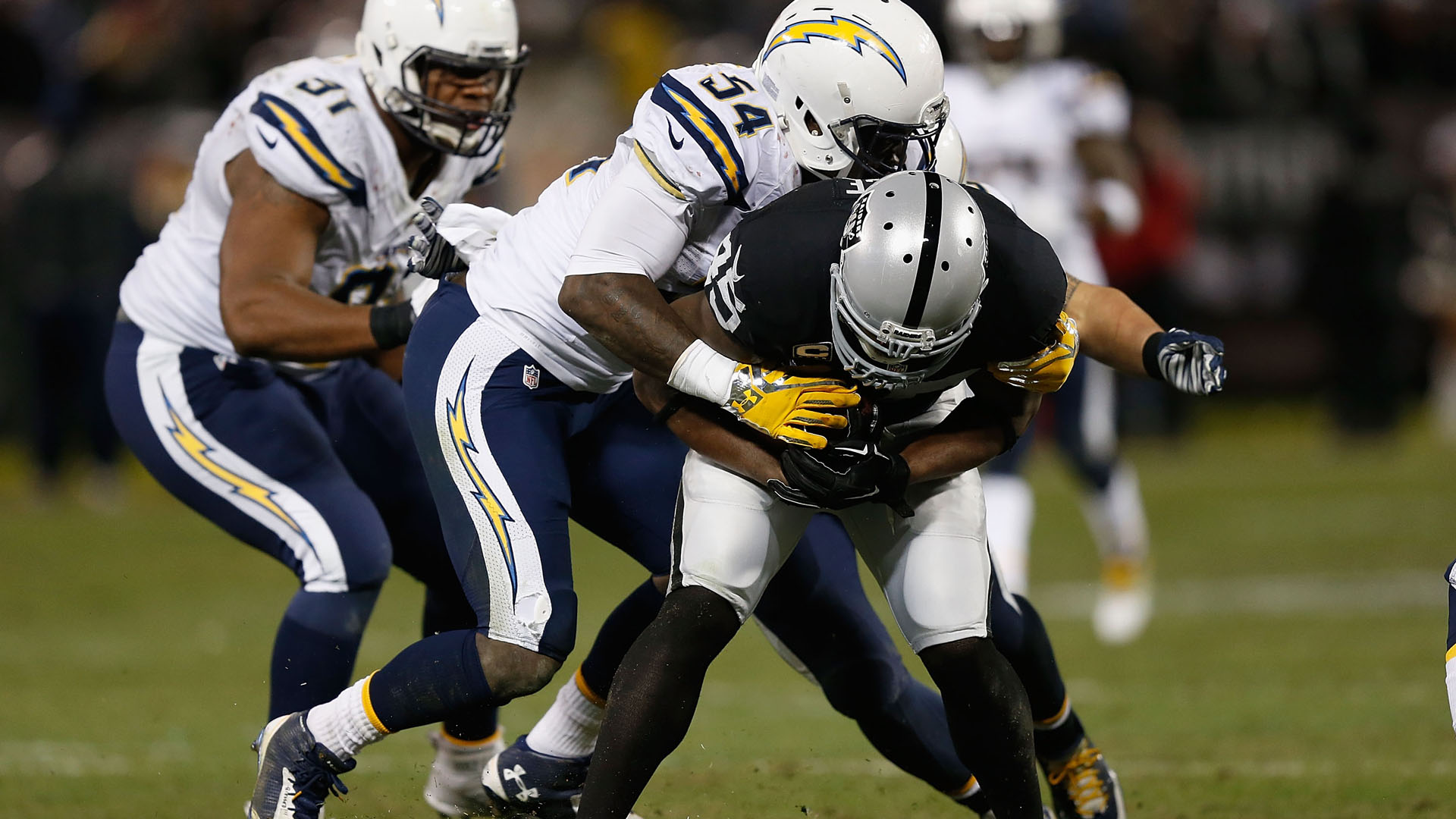 Marcel Reece of the Oakland Raiders is tackled by linebacker Melvin Ingram of the San Diego Chargers on Dec. 24, 2015. (Credit: Lachlan Cunningham/Getty Images)