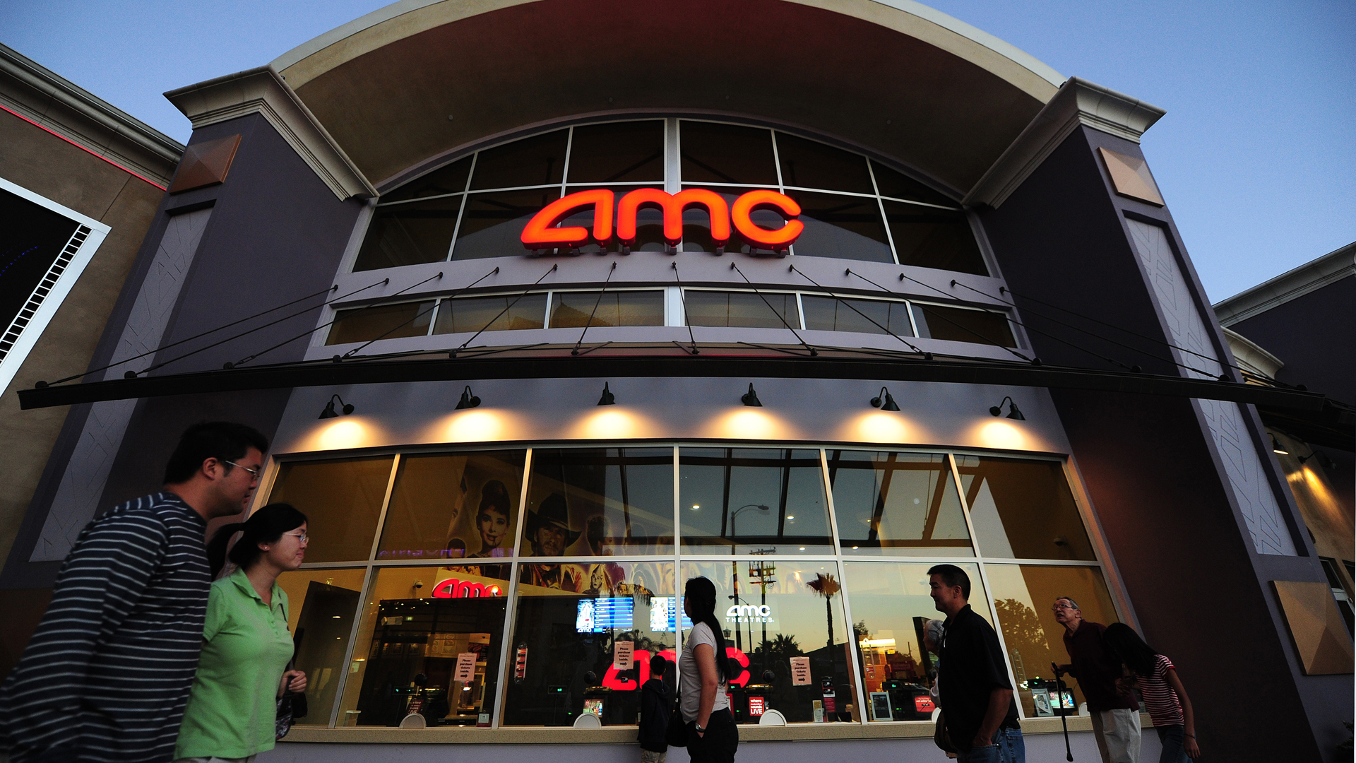 People walk past movie theaters of the US cinema chain AMC Entertainment in Monterey Park on May 22, 2012. (Credit: FREDERIC J.BROWN/AFP/GettyImages)