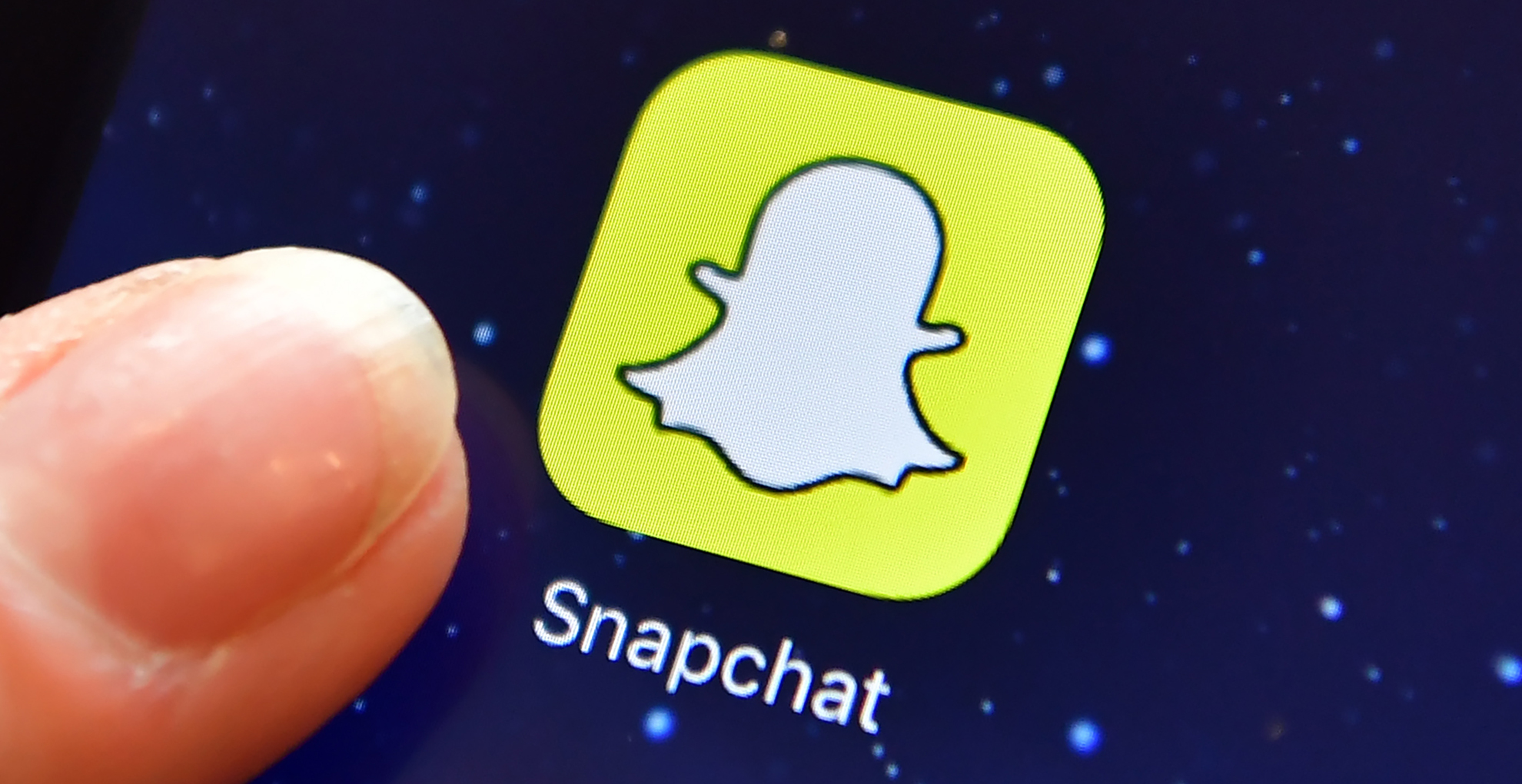 A finger is posed next to the Snapchat app logo on an iPad on Aug. 3, 2016 in London, England. (Credit: Carl Court/Getty Images)