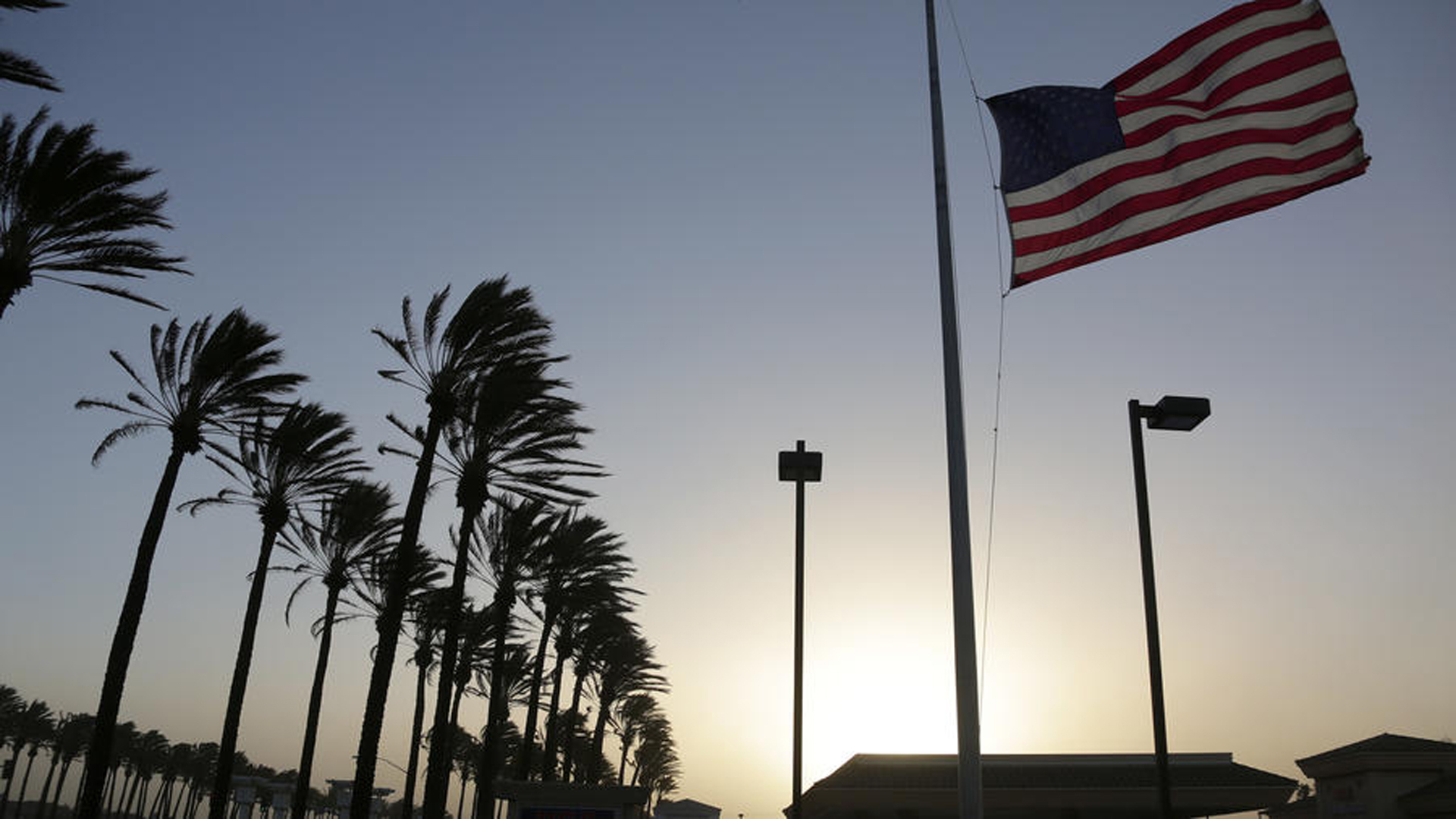 In this file photo, palm trees sway and a flag flutters in gusty winds in Fontana as Santa Ana winds move into Southern California. (Credit: Irfan Khan / Los Angeles Times)