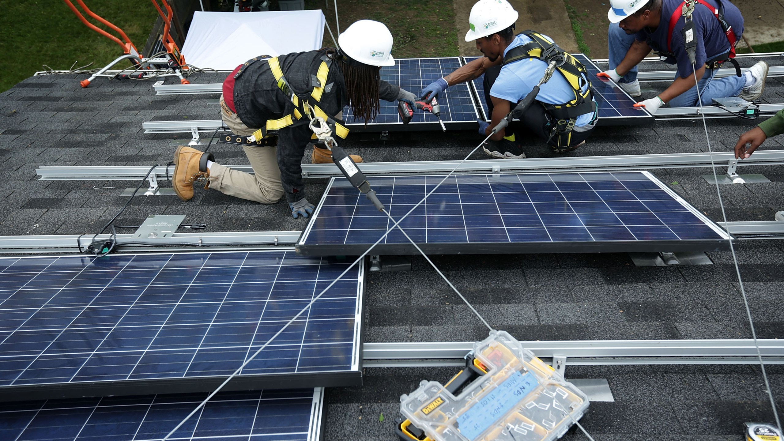 Workers put solar panels down during an installation on May 3, 2016, in Washington, DC. (Alex Wong / Getty Images)