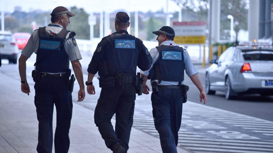 Police walk outside the international terminal as they patrol Sydney Airport on July 31, 2017. Four men accused of plotting to bring down a plane from Sydney planned to use poisonous gas or a crude bomb disguised as a meat mincer, reports said on July 31, with Australian officials calling preparations 'advanced'. (Credit: PETER PARKS/AFP/Getty Images)