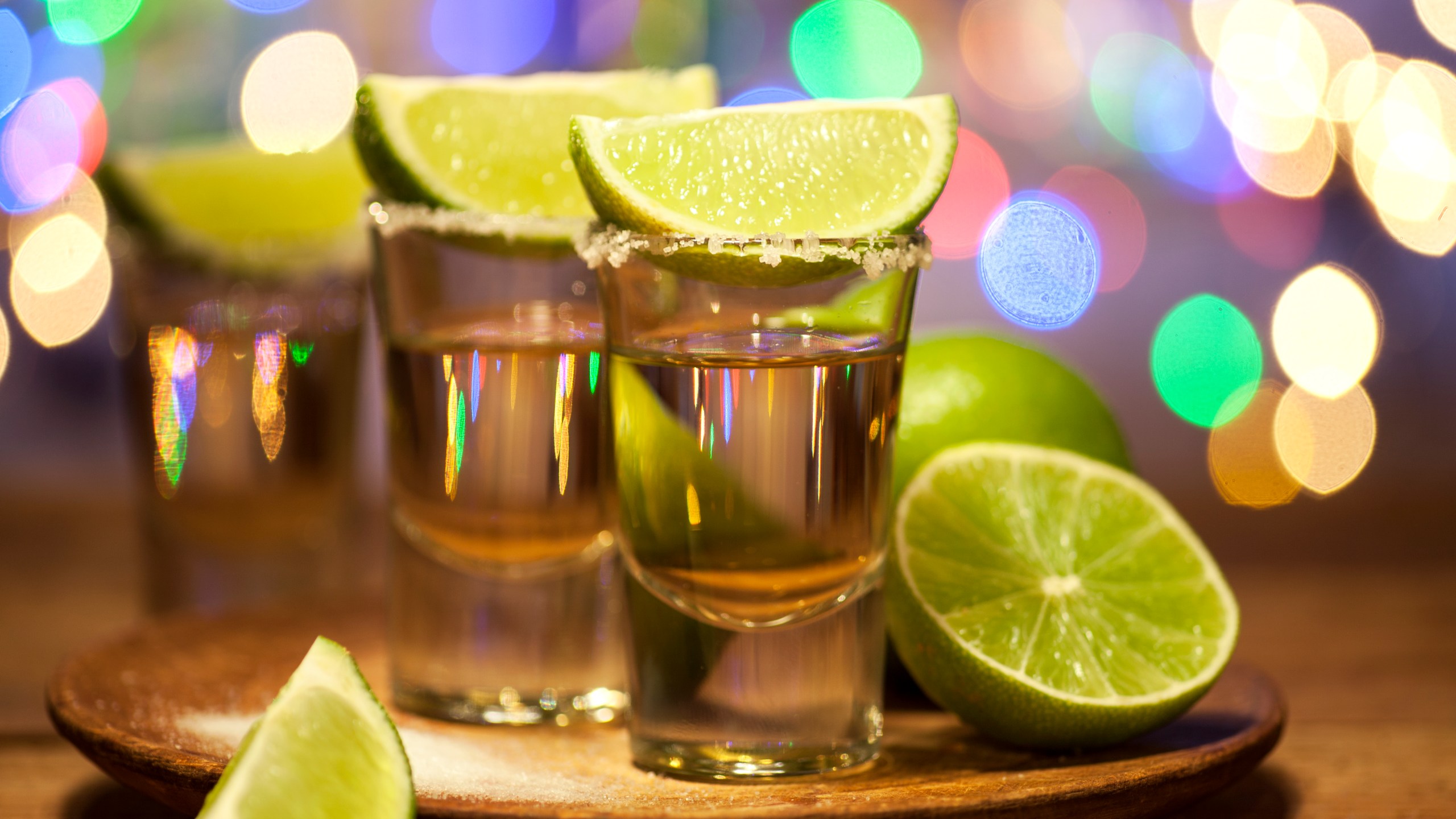 Gold tequila shots with lime fruits are seen in this file photo. (Credit: iStock / Getty Images Plus)