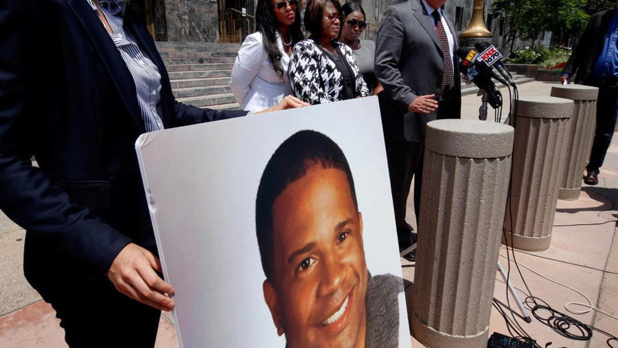 A poster showing the face of Dennis "Todd" Rogers, who was killed in a deputy-involved shooting in Ladera Heights in March, is held up at a press conference in Los Angeles. (Credit: Francine Orr / Los Angeles Times)