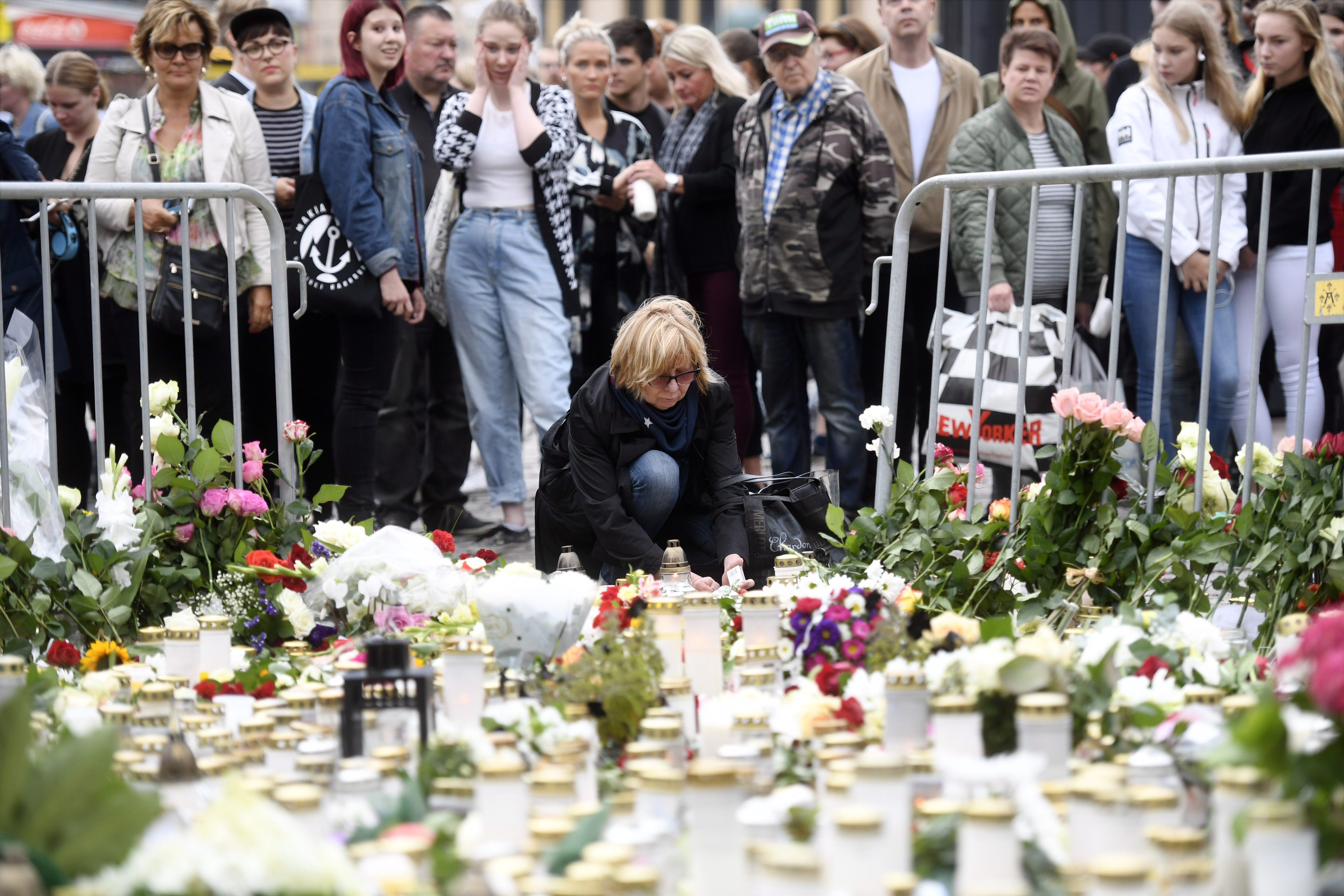 Candles and flowers are left at the makeshift memorial by well wishers for the victims of Friday's stabbings at the Turku Market Square in Finland on Aug. 19, 2017. (Credit: Vesa Moilanen / AFP / Getty Images)