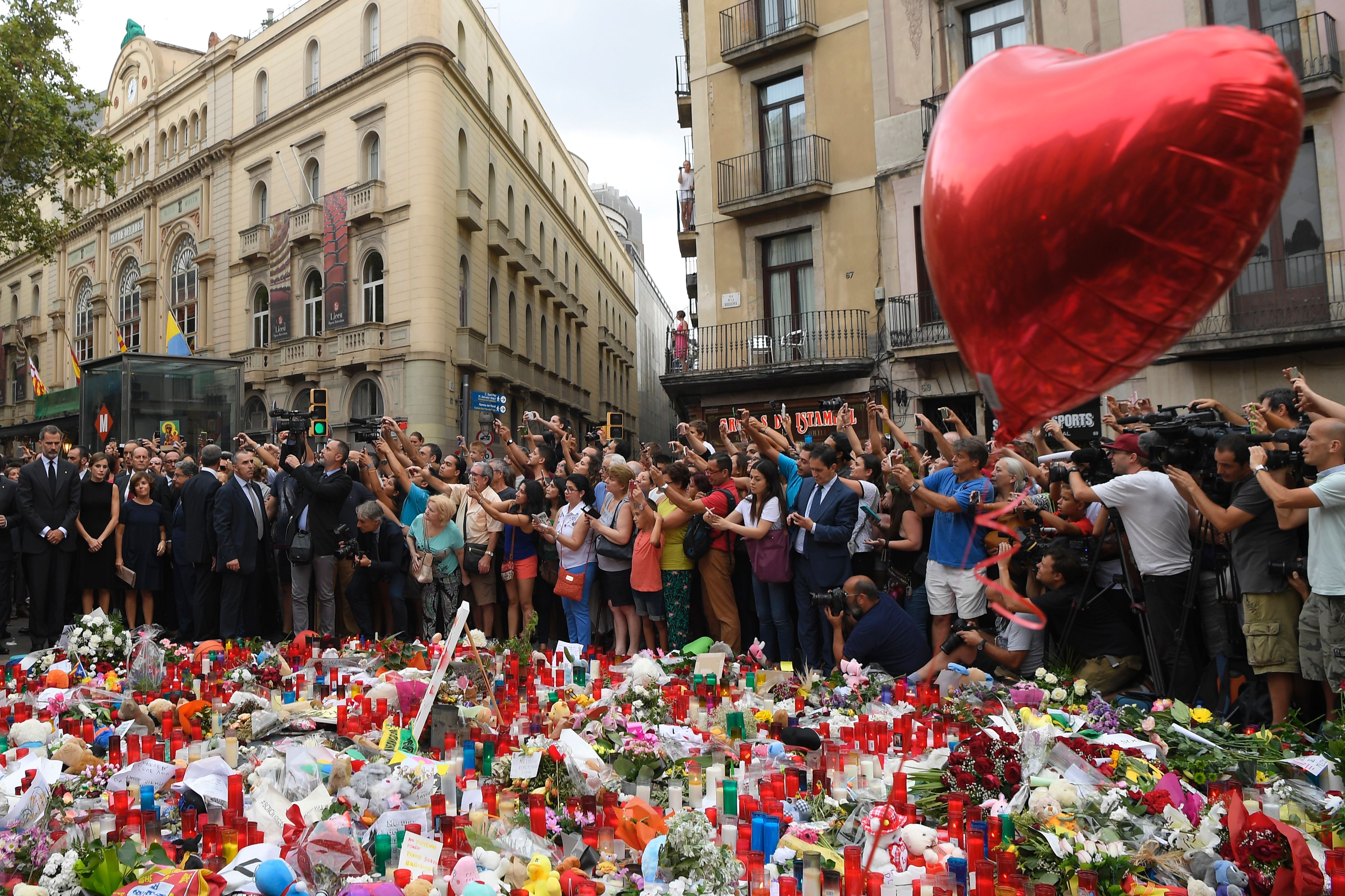 Spain's King Felipe VI (left) and Spain's Queen Letizia (second left) pay tribute to the victims of the Barcelona attack on Las Ramblas boulevard, in Barcelona on August 19, 2017, two days after a van plowed into the crowd, killing 13 persons and injuring over 100. (Credit: Lluis Gene / AFP / Getty Images)