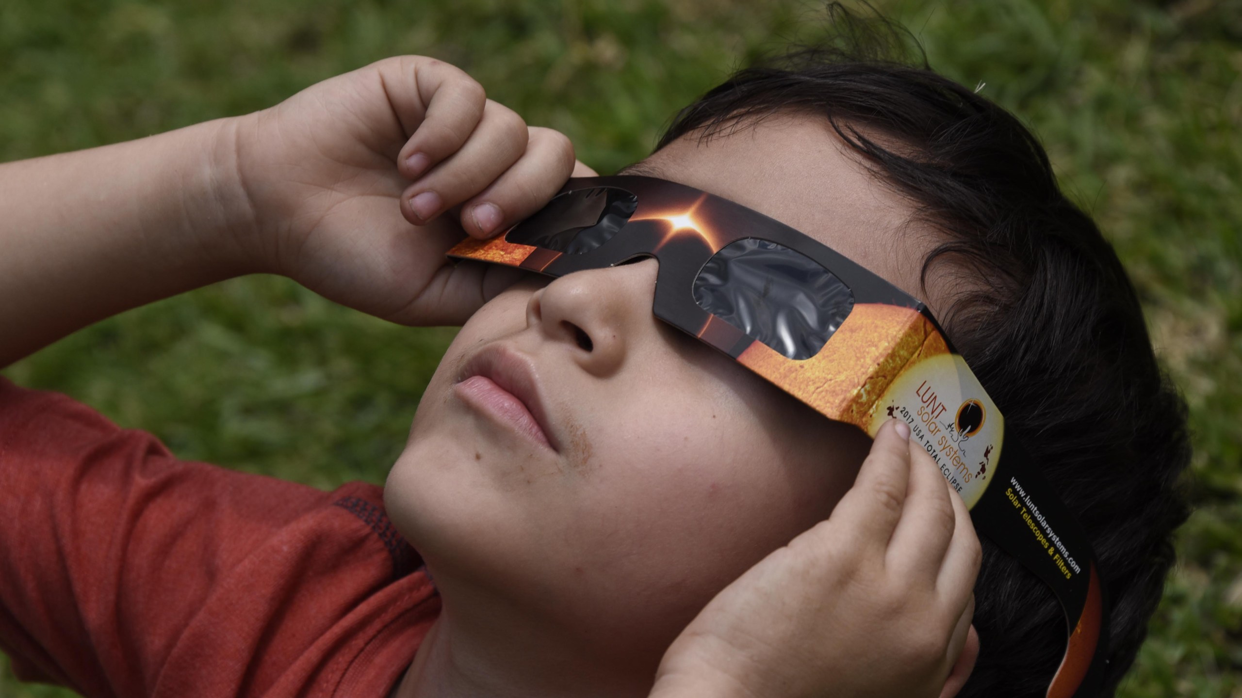 People visiting to Miraflores Museum watch the partial solar eclipse through special glasses, in Guatemala City on August 21, 2017. (Credit: JOHAN ORDONEZ/AFP/Getty Images)