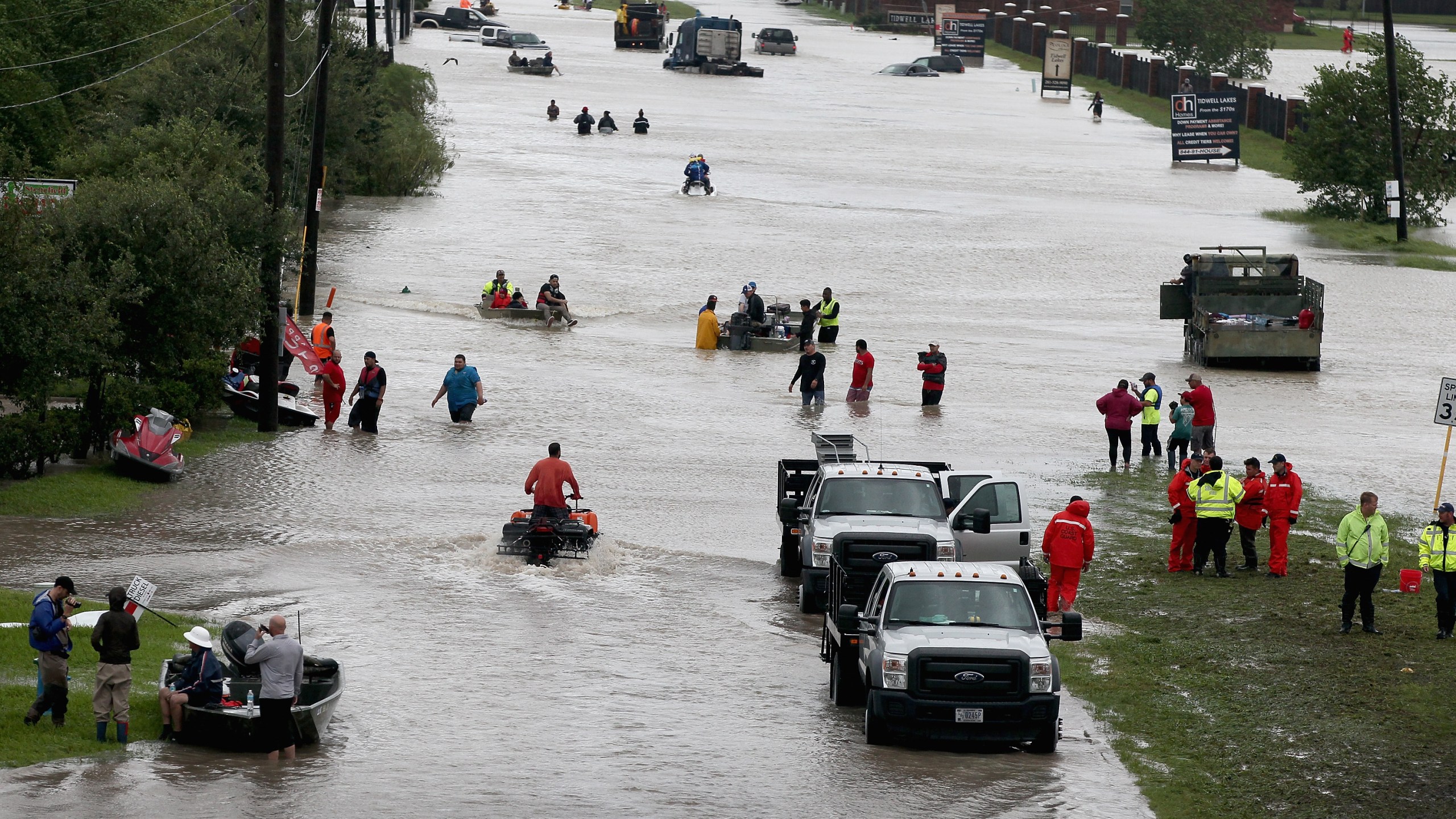 People make their way out of a flooded neighborhood after it was inundated with rain water following Hurricane Harvey on August 29, 2017 in Houston, Texas. (Credit: Scott Olson/Getty Images)