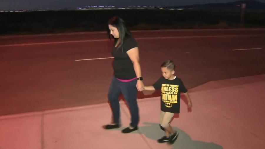 Cynthia Rosas and her son, Richard, walk in their Adelanto neighborhood on Aug. 14, 2017. (Credit: KTLA)