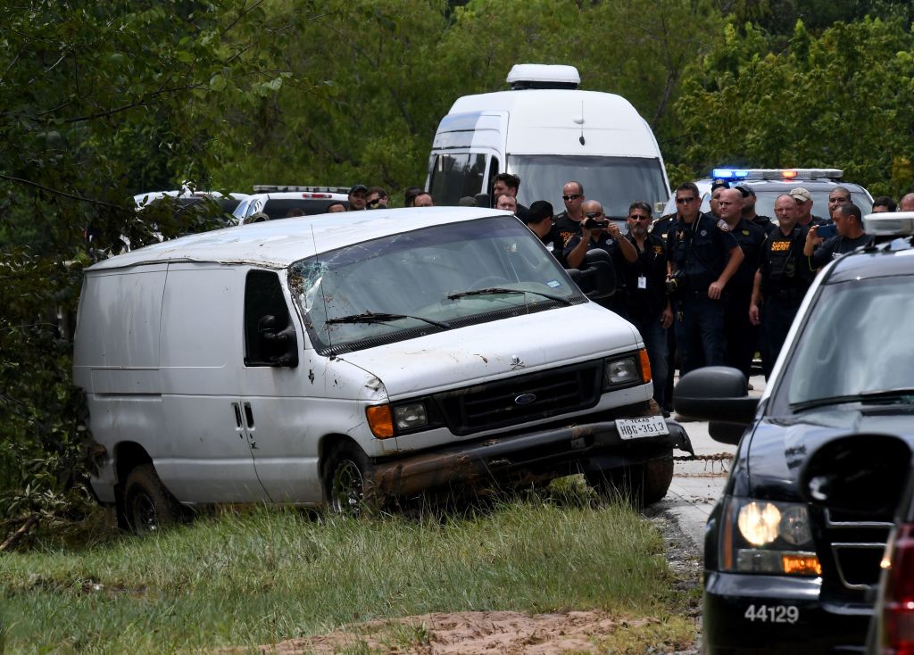 Police investigators watch as the van containing the six members of the the Saldivar family who died is towed to the road after they crashed their van into Greens Bayou as they tried to flee Hurricane Harvey during heavy flooding in Houston, Texas on August 30, 2017. / AFP PHOTO / MARK RALSTON (Photo credit should read MARK RALSTON/AFP/Getty Images)