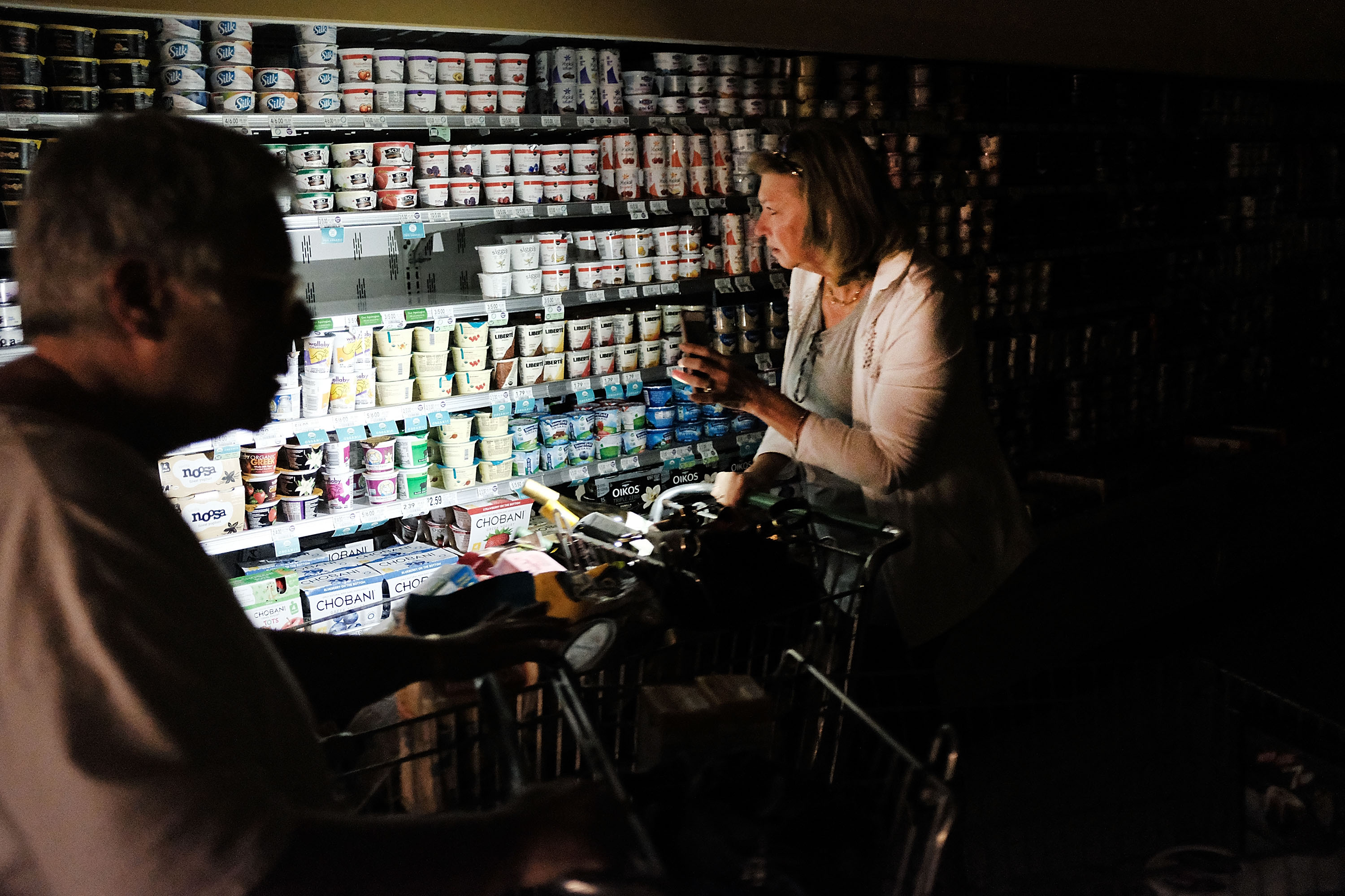 People shop in a supermarket, one of the few open, with limited electricity three days after Hurricane Irma swept through the area on September 13, 2017 in Naples, Florida. (Credit: Spencer Platt/Getty Images)