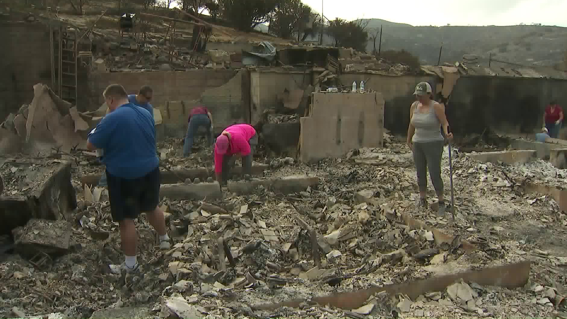 Friends of a Sunland couple who lost their home in the La Tuna Fire return to the rubble on Sept. 4, 2017. (Credit: KTLA)