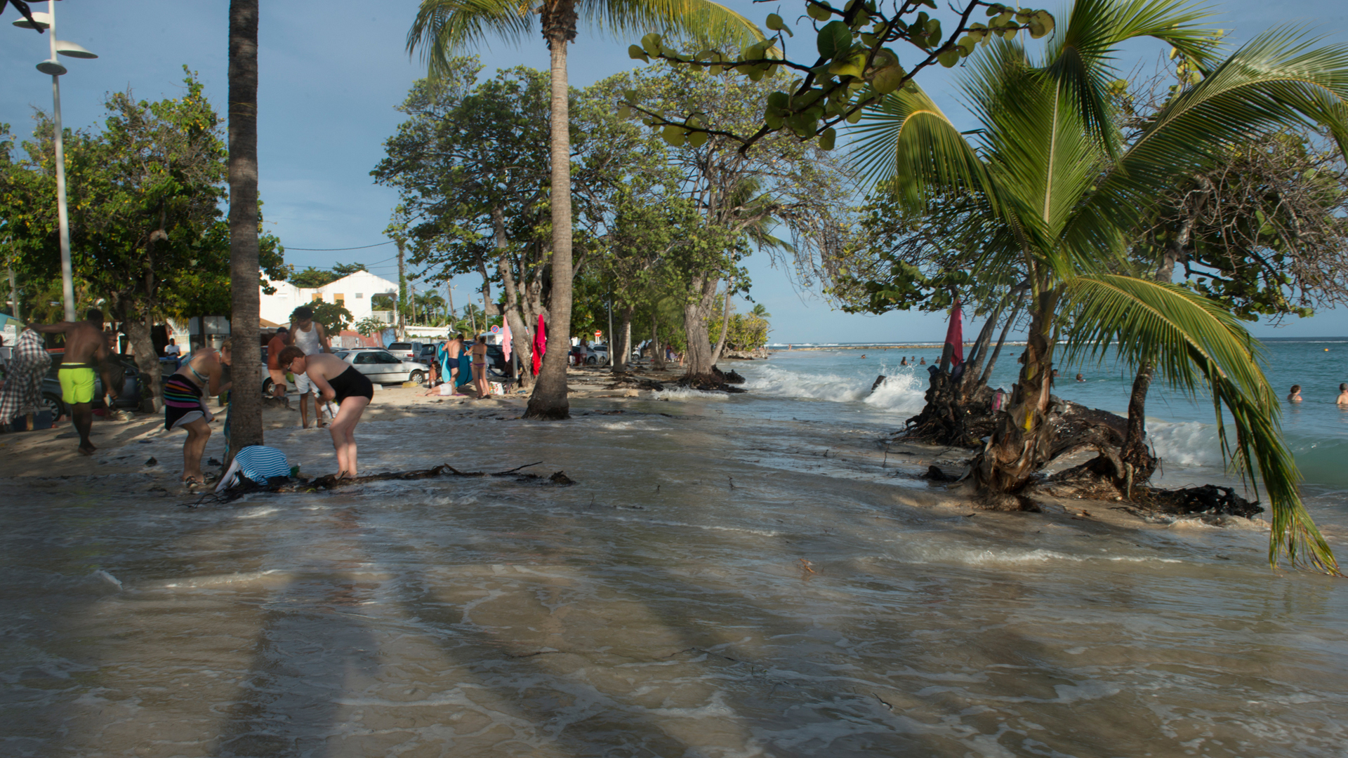 People collect their belongings off the beach of Sainte-Anne, on the French island of Guadeloupe, during high tides ahead of Hurricane Jose on Sept. 8, 2017. (Credit: Helene Valenzuela/AFP/Getty Images)