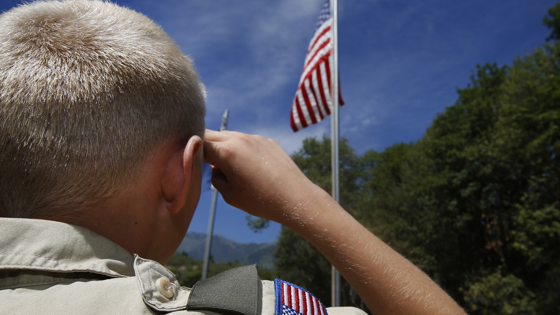 A Boy Scout salutes the American flag at camp Maple Dell on July 31, 2015 outside Payson, Utah. (Credit: George Frey/Getty Images)