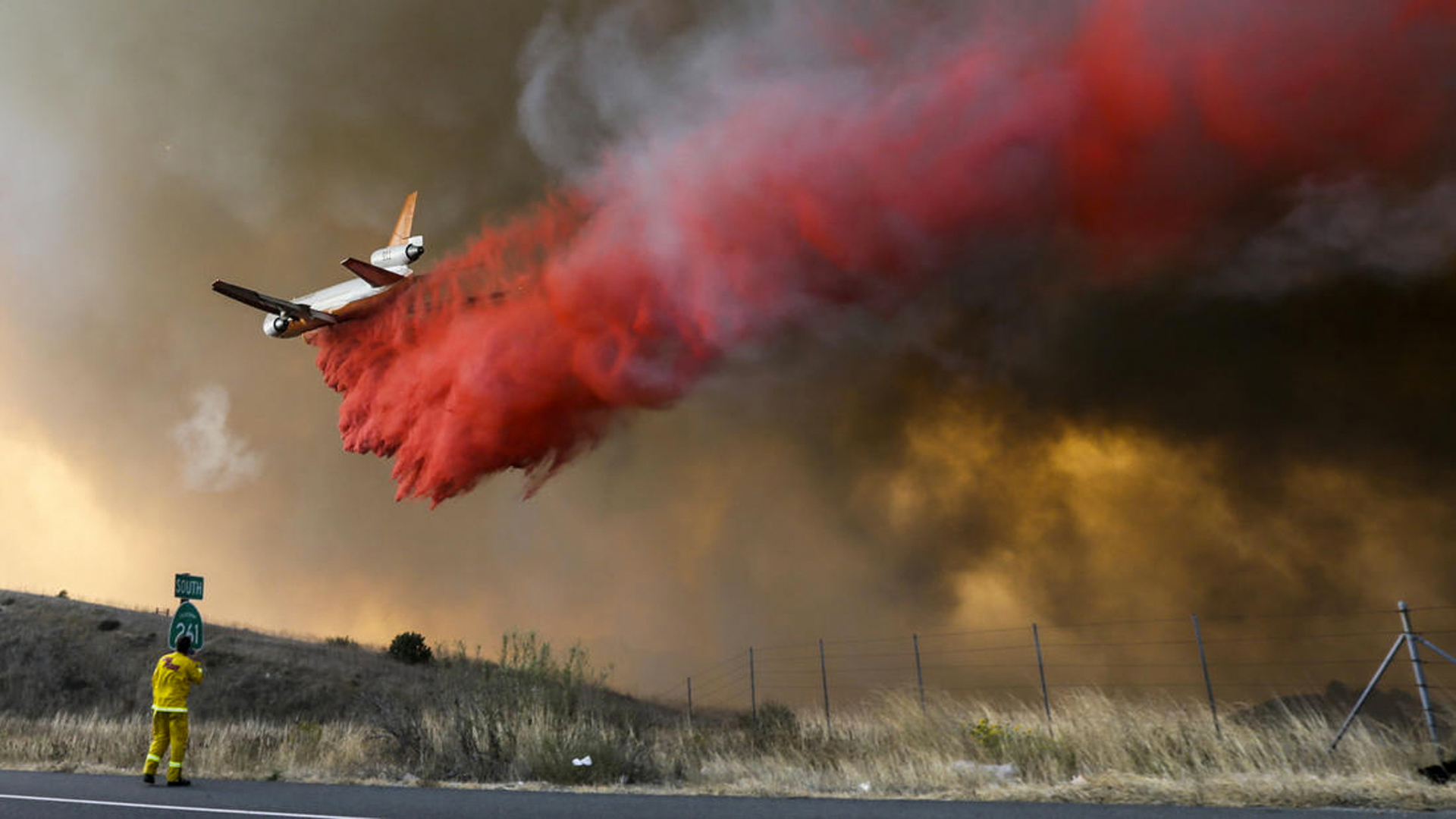 A DC-10 makes a drop as the Anahiem Hills fire rages along 241 and Santiago Canyon Rd in Orange. (Credit: Irfan Khan/Los Angeles Times)