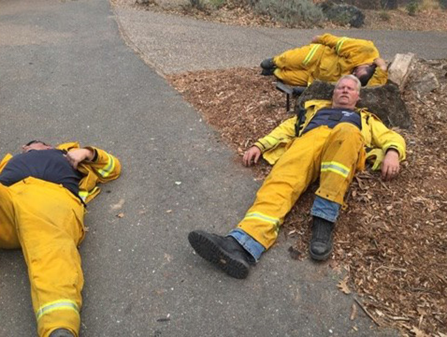 Firefighters with the Sebastopol Fire Department use the ground and a rock as a bed to get some rest. (Credit: Sebastopol Fire Department)