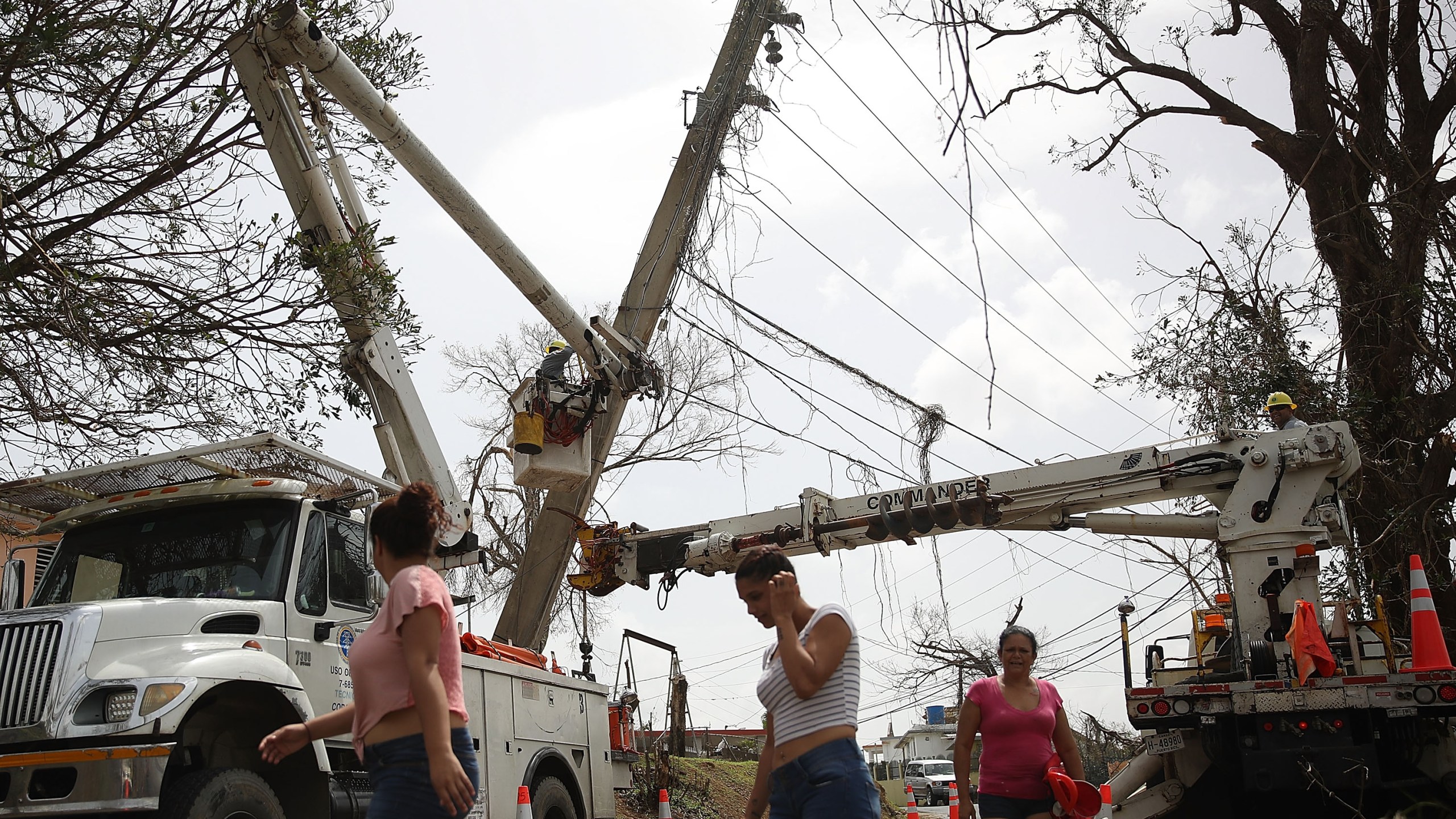 An electrical crew attempts to repair power lines that were knocked over Hurricane Maria passed through on Sept. 27, 2017, in Corozal, Puerto Rico. (Credit: Joe Raedle/Getty Images)