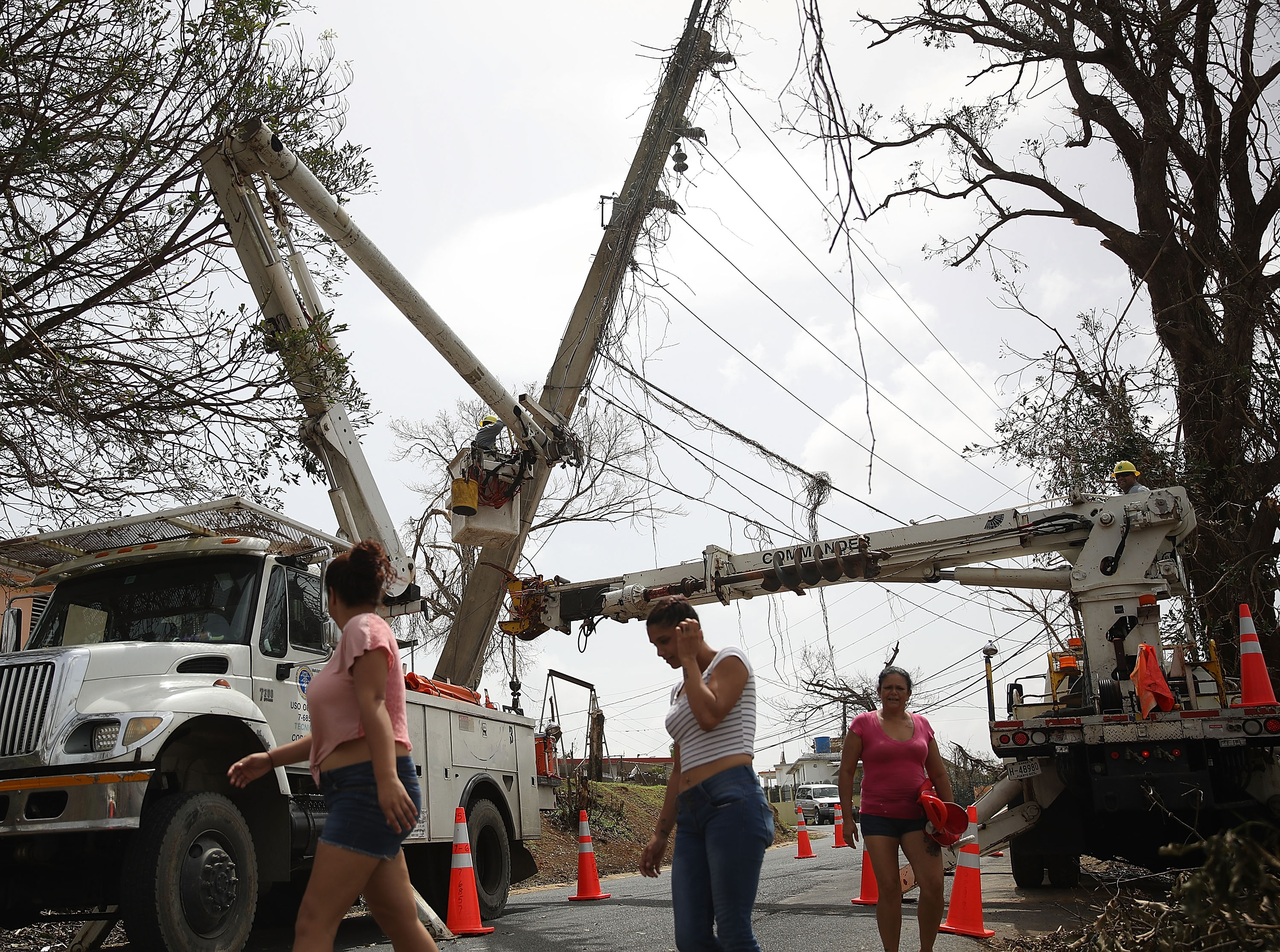 An electrical crew attempts to repair power lines that were knocked over Hurricane Maria passed through on Sept. 27, 2017, in Corozal, Puerto Rico. (Credit: Joe Raedle/Getty Images)