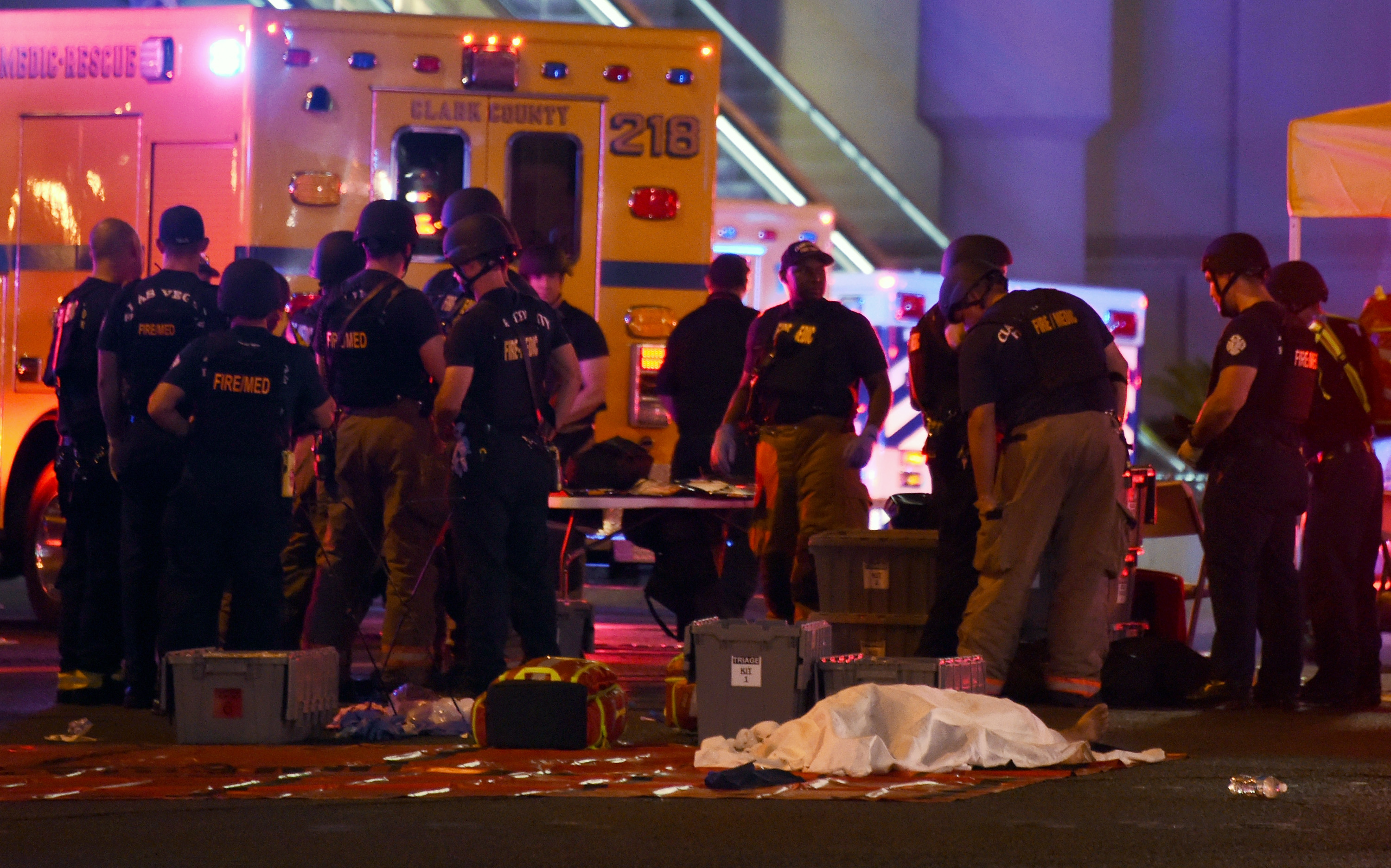 A body lies under a sheet as fire and rescue personnel gather at the intersection of Las Vegas Boulevard and Tropicana Ave. after a mass shooting at a country music festival nearby on October 1, 2017 in Las Vegas, Nevada. (Credit: Ethan Miller/Getty Images)