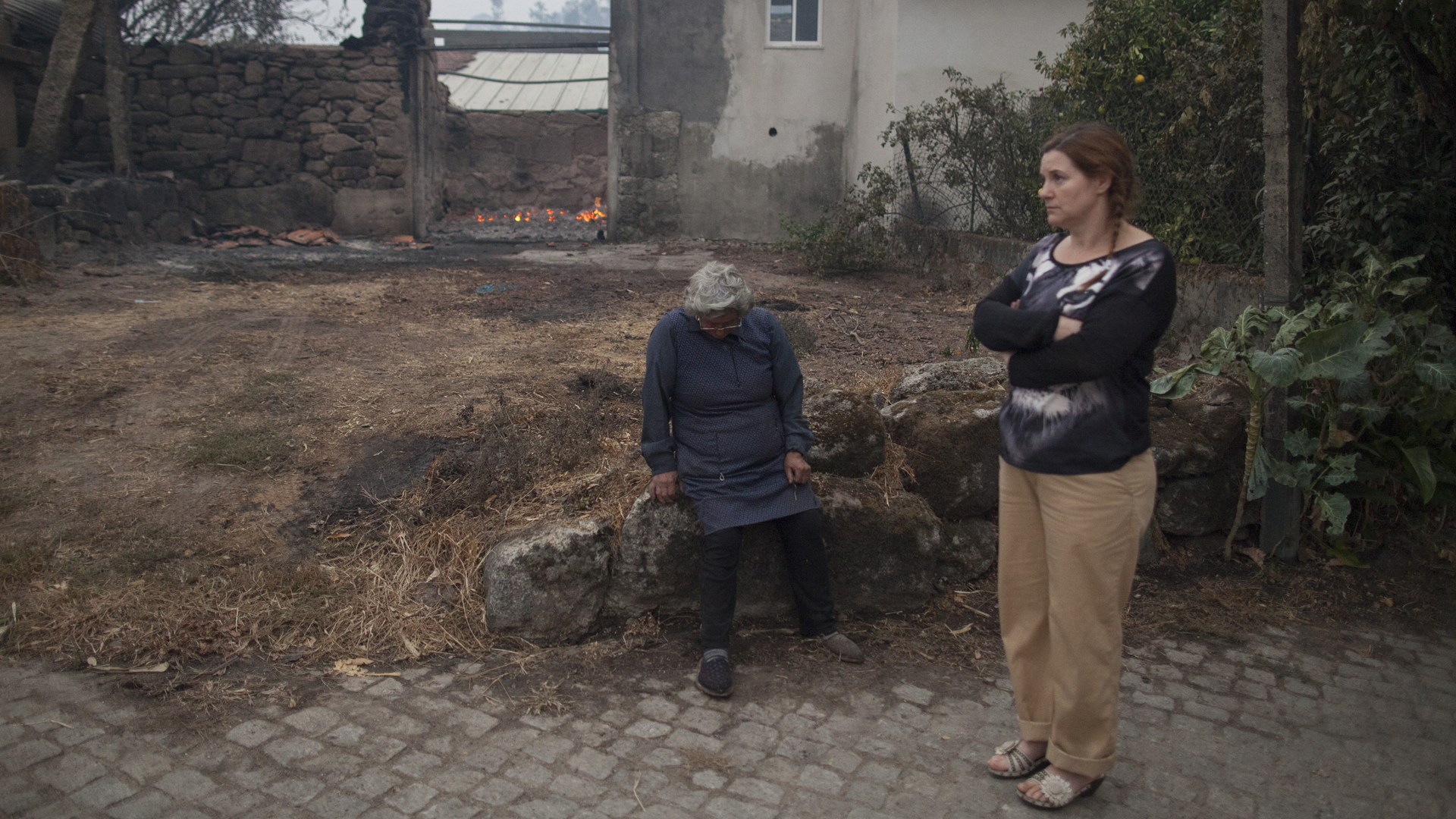 Women are seen in the village of Vila Nova, Portugal on Oct. 16, 2017, after wildfires raged through the area and burned down houses. (Credit: Pablo Blazquez Dominguez/Getty Images)