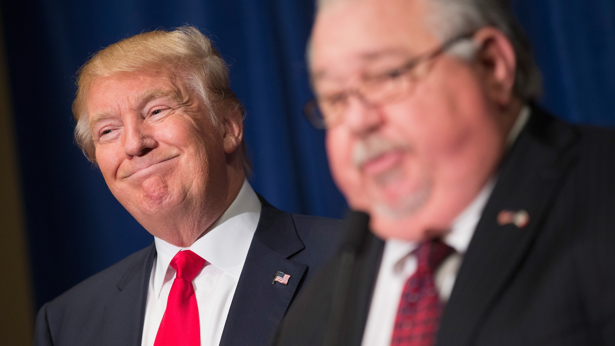 Republican presidential candidate Donald Trump listens as Sam Clovis speaks at a press conference on Aug. 25, 2015, in Dubuque, Iowa. (Credit: Scott Olson / Getty Images)