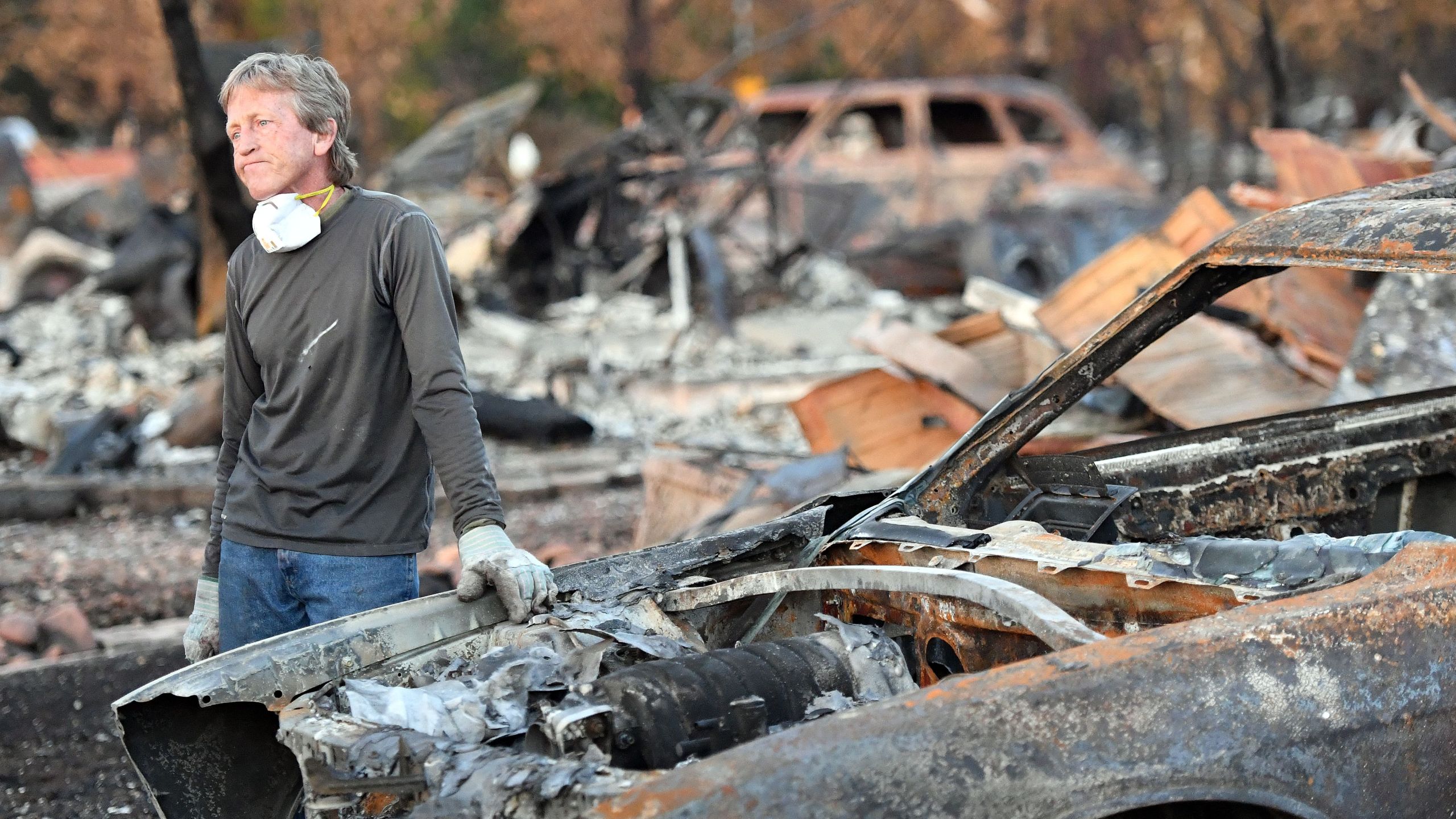 Car collector Gary Dower speaks with neighbors at his fire-destroyed home in Santa Rosa, California on Oct. 20, 2017. (Credit: Josh Edelson / AFP / Getty Images)