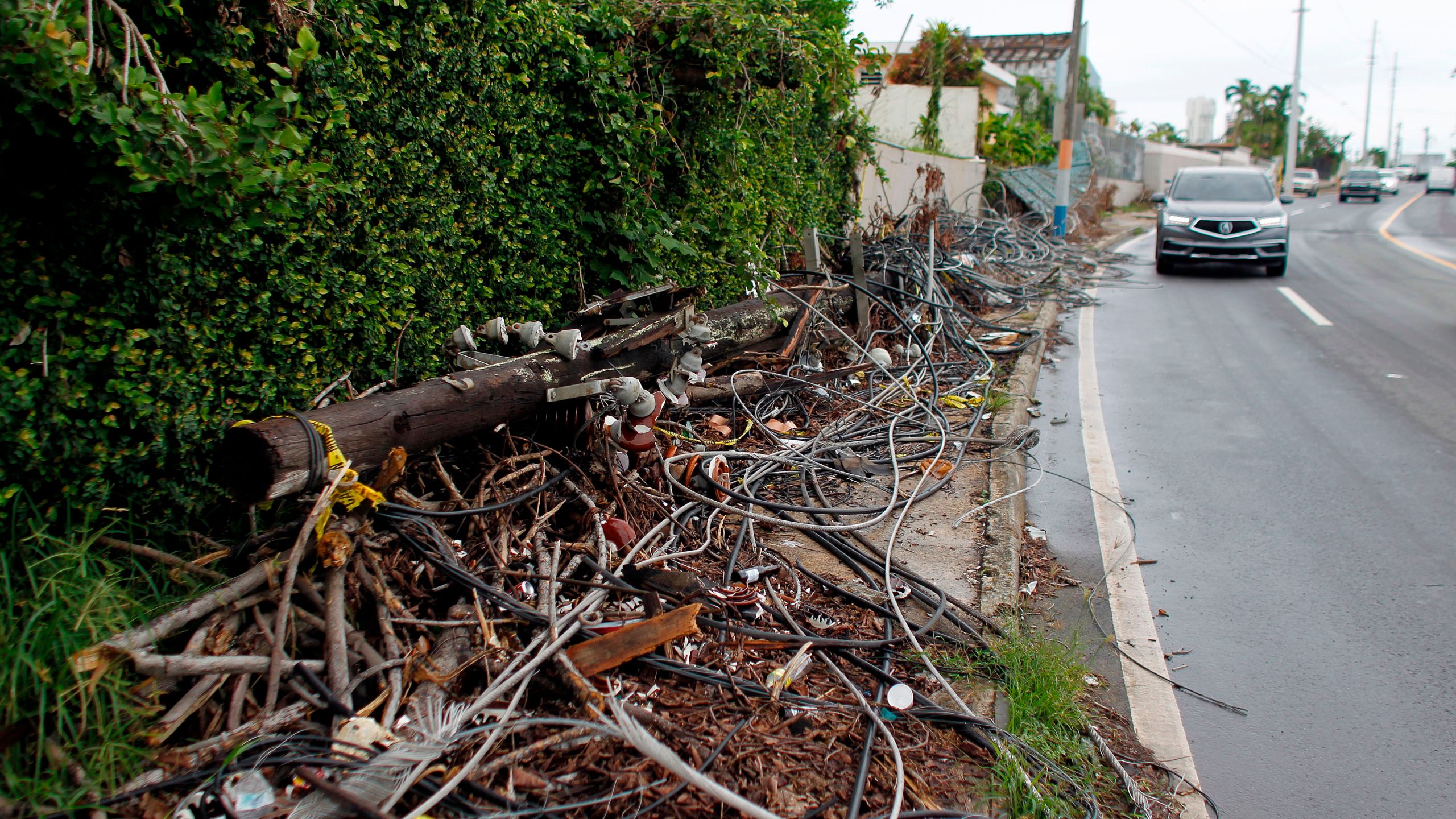 Power line poles and lines downed by the passing of Hurricane Maria lie on a sidewalk in San Juan, Puerto Rico on Nov. 7, 2017. (Credit: Ricardo Arduengo / AFP / Getty Images)