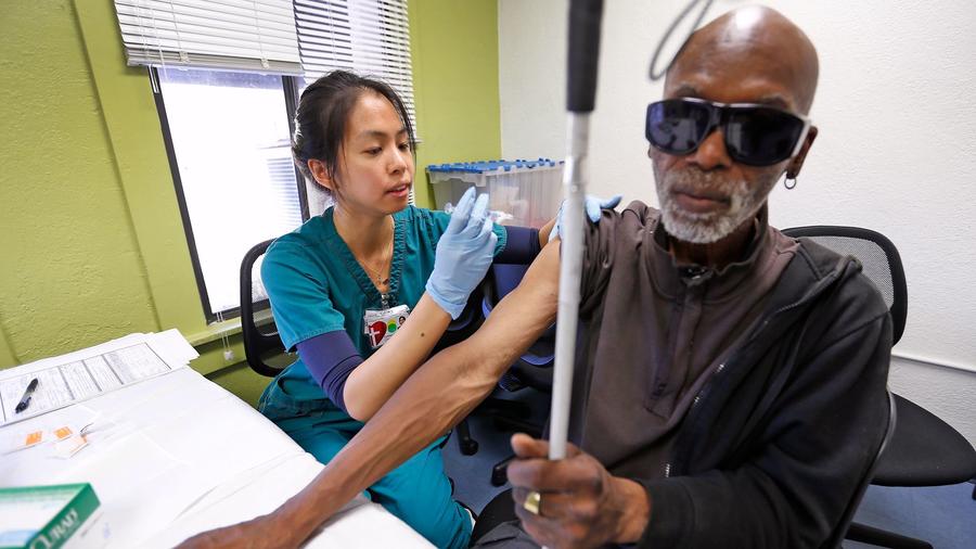 Carolyn Angela Chen, a nurse with Los Angeles Christian Health Centers, gives a free hepatitis A vaccination to Marcel Anthony, 63, at Joshua House Clinic on skid row in L.A. in this undated photo. (Credit: Al Seib / Los Angeles Times)