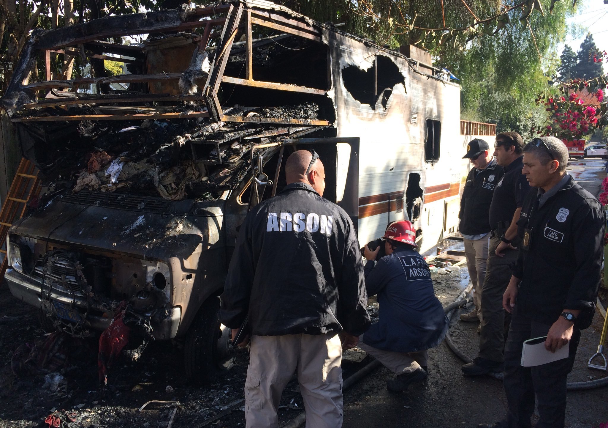 Fire investigators examine the shell of a burned RV after a fatal fire Nov. 20, 2017, in Rancho Park in a photo tweeted by LAFD's Erik Scott.