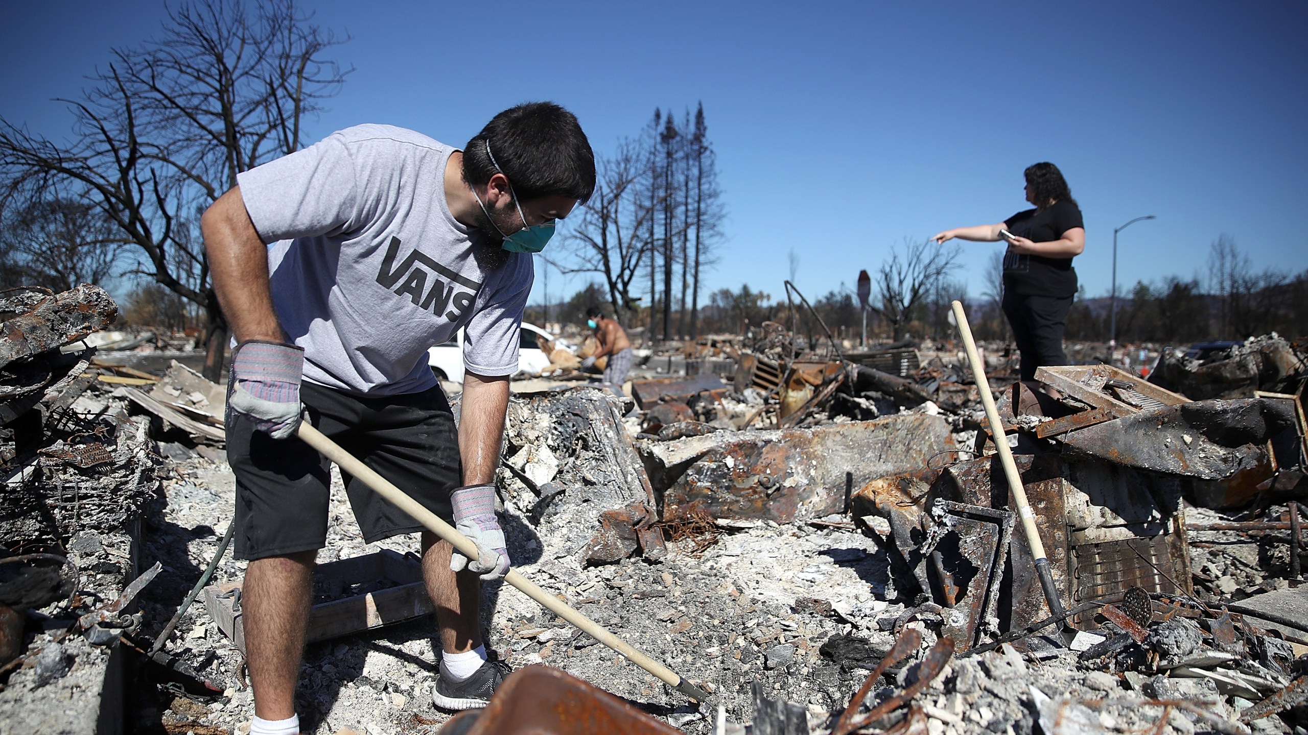 Ben Hernandez Jr., left, sifts through the remains of his Coffey Park home that was destroyed by the Tubbs Fire on Oct. 23, 2017 in Santa Rosa, California. (Credit: Justin Sullivan/Getty Images)