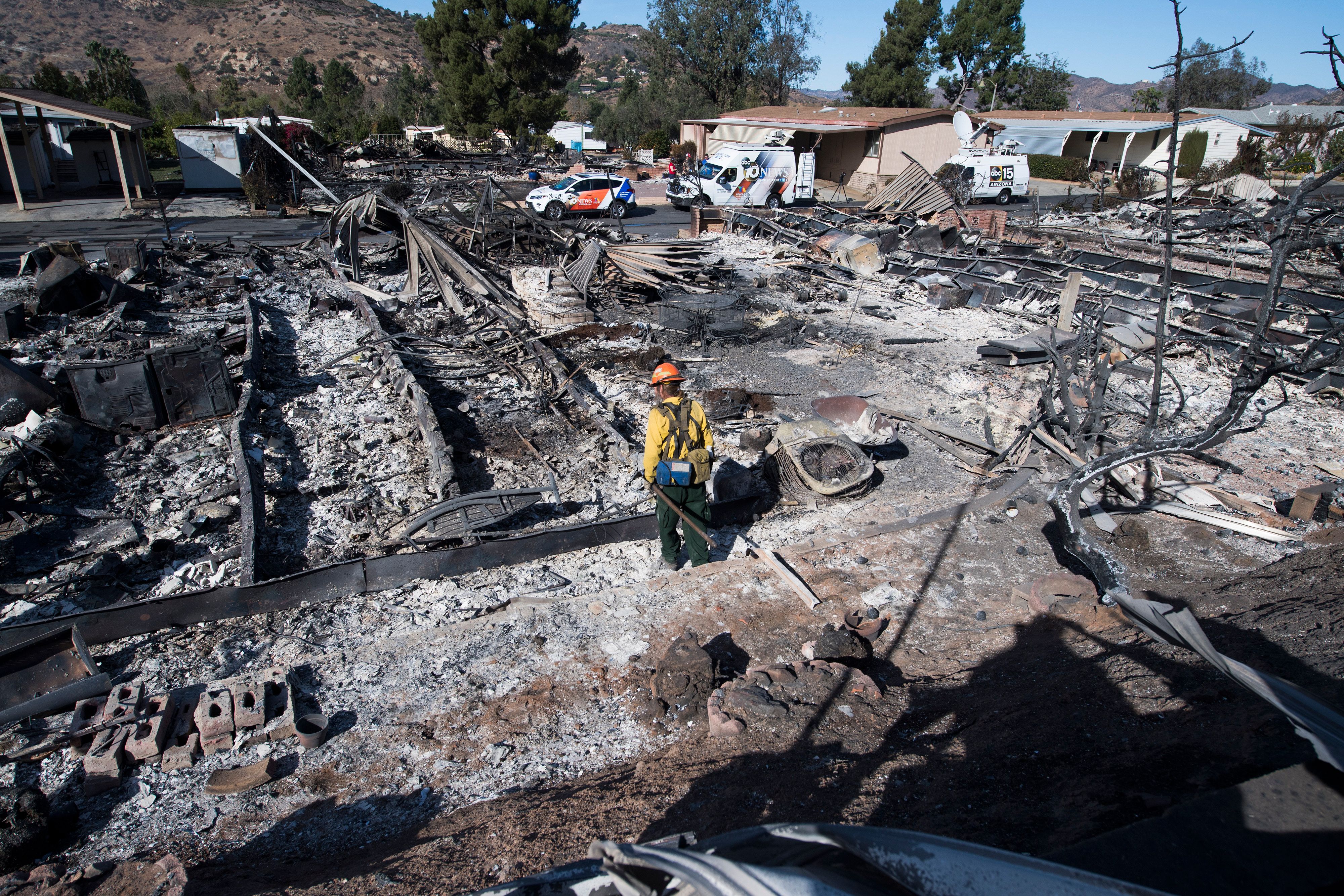 Firefighter Dean Wilson looks for hot spots in the remains of dozens of homes destroyed by the Lilac Fire at a retirement community in Fallbrook, Dec. 8, 2017. (Credit: AFP PHOTO / Robyn Beck)