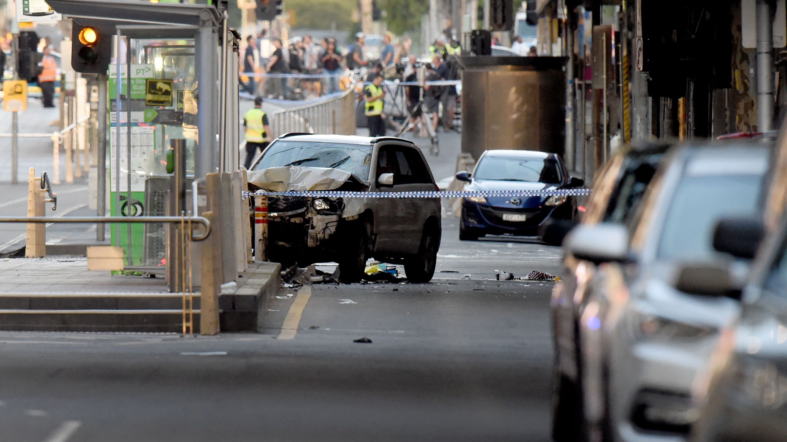 A white SUV sits in the middle of the road as police and emergency personnel work at the scene of where a car ran over pedestrians in Melbourne on December 21, 2017. (Credit: MAL FAIRCLOUGH/AFP/Getty Images)