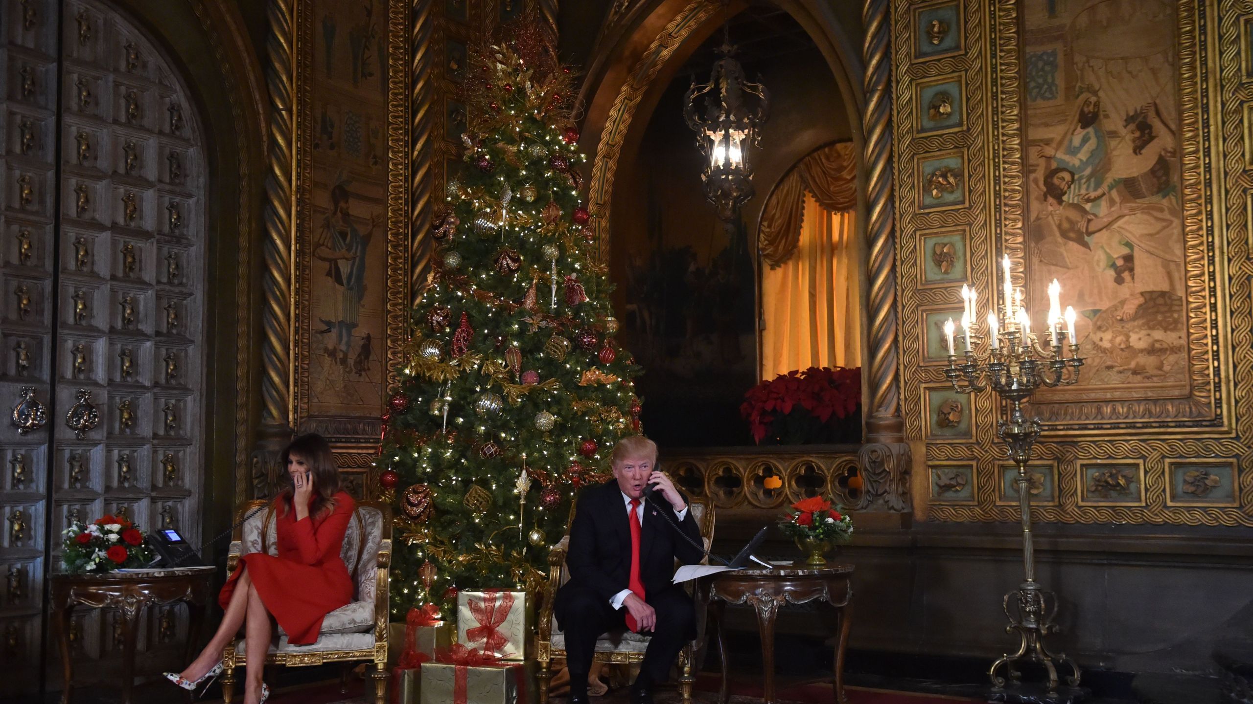 President Donald Trump and First Lady Melania Trump participate in NORAD Santa Tracker phone calls at the Mar-a-Lago resort in Palm Beach, Florida, on Dec. 24, 2017. (Credit: Nicholas Kamm / AFP / Getty Images)