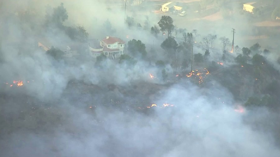 Flames surround a home in the Liberty Fire near Murrieta on Dec. 7, 2017. (Credit: KTLA)