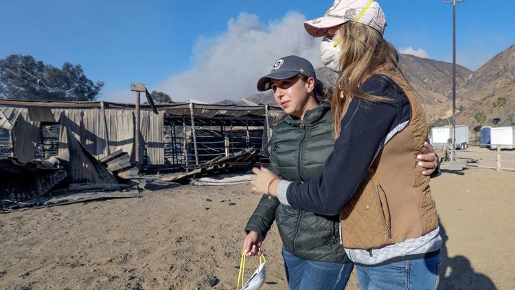 Virginia Padilla, left, who lost 29 horses at her Padilla Ranch on Little Tujunga Canyon Road, is comforted by friend Shelby Hope. The horses, many of them boarded animals, were killed in the Creek fire. (Credit: Irfan Khan / Los Angeles Times)