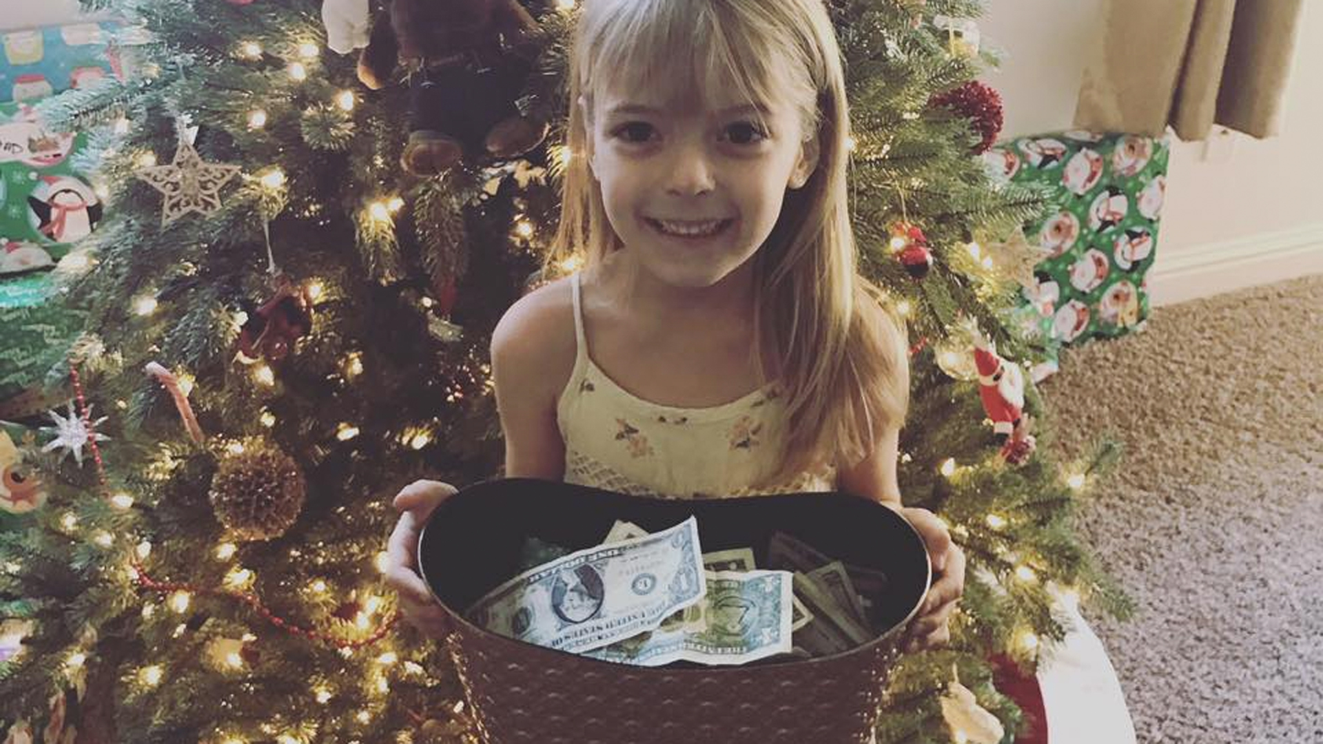 Faye Segraves is seen in a family photo with the money she collected for the Wildland Firefighter Foundation.