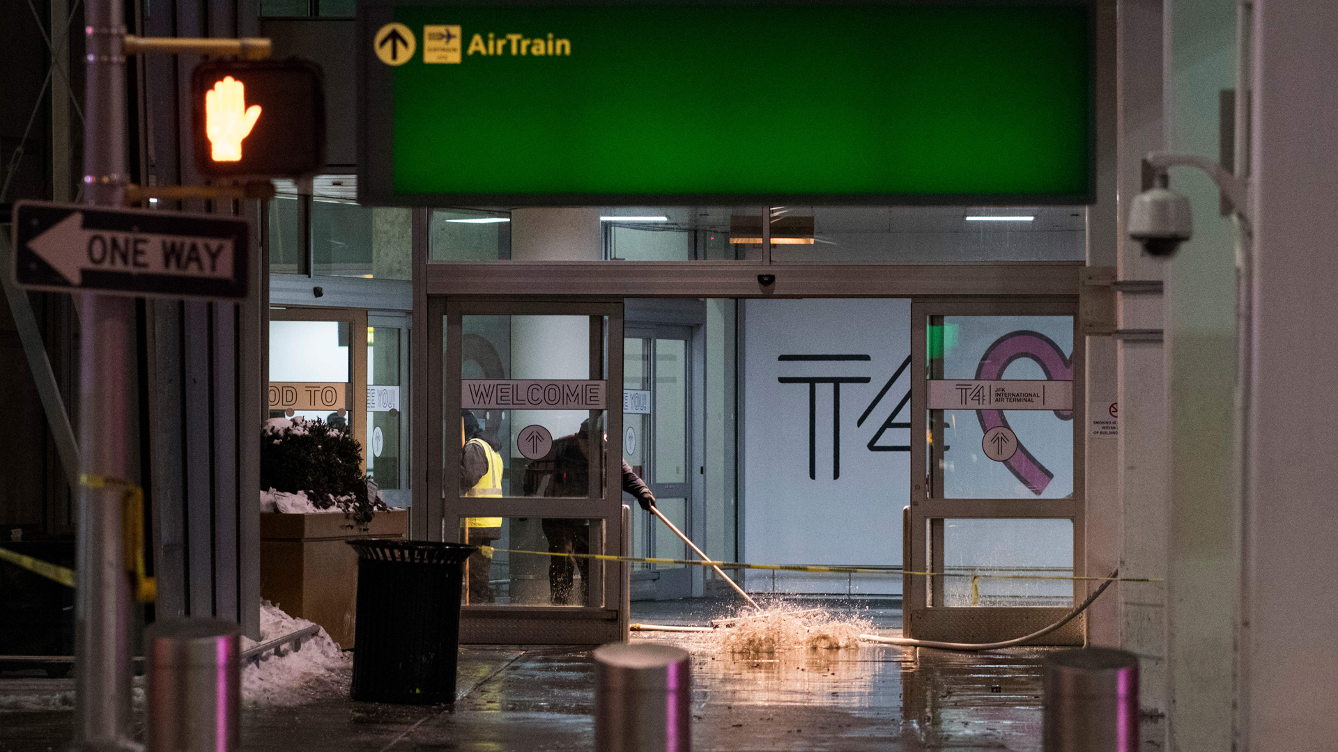 Workers sweep water from a floor of the arrivals area at John F. Kennedy International Airport's Terminal 4, in New York City, on Jan. 7, 2018. (Credit: Jewel Samad/AFP/Getty Images)