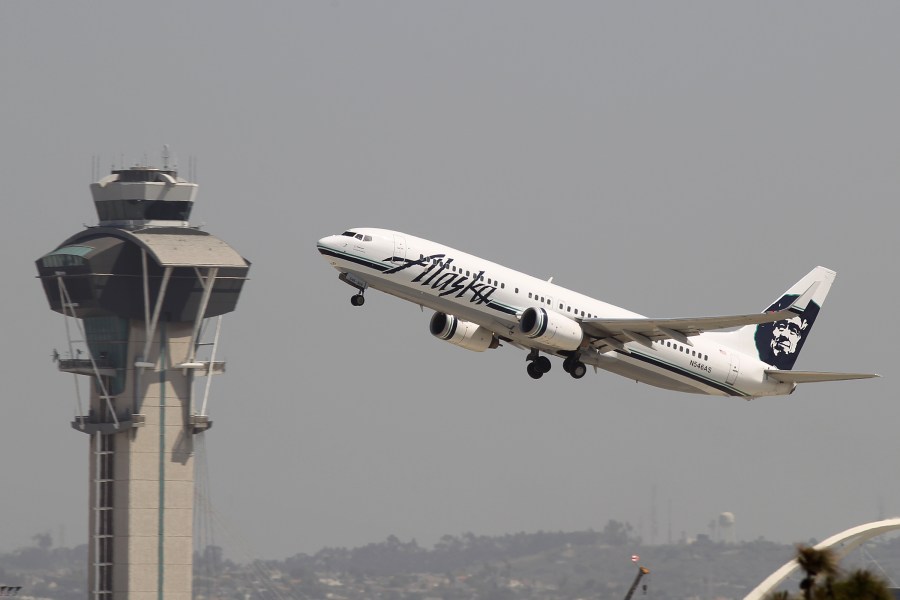 An Alaska Airlines jet passes the air traffic control tower at Los Angeles International Airport during take-off on April 22, 2013. (Credit: David McNew/Getty Images)