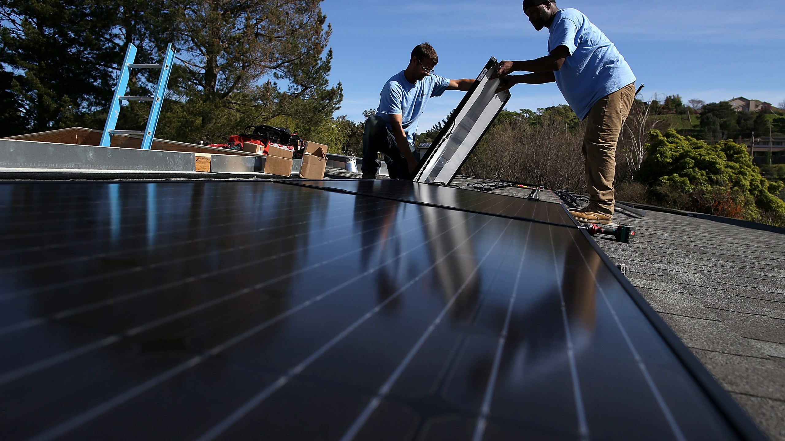 Craig Powell and Edwin Neal install solar panels on the roof of a home on Feb. 26, 2015 in San Rafael, California. (Credit: Justin Sullivan/Getty Images)