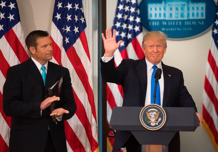 President Donald Trump waves after speaking alongside Kansas Secretary of State Kris Kobach, left, during the first meeting of the Presidential Advisory Commission on Election Integrity in the Eisenhower Executive Office Building next to the White House in Washington, D.C., July 19, 2017. (Credit: SAUL LOEB/AFP/Getty Images)