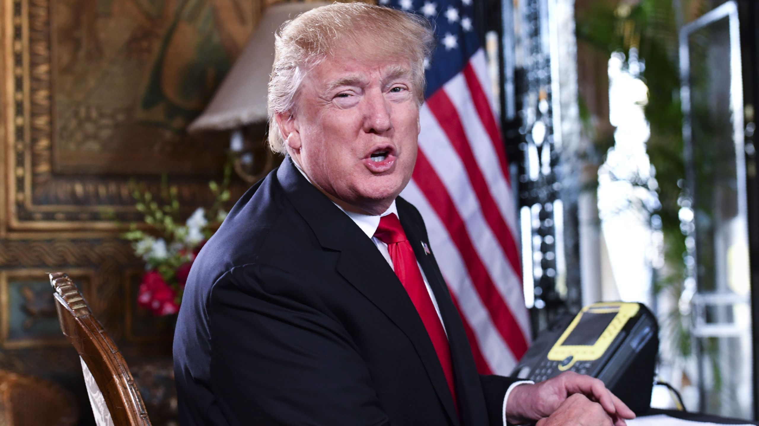 U.S. President Donald J. Trump speaks to the media before participating in a video teleconference calls with military members on Christmas Eve in Palm Beach, Florida on December 24, 2017. (Credit: NICHOLAS KAMM/AFP/Getty Images)