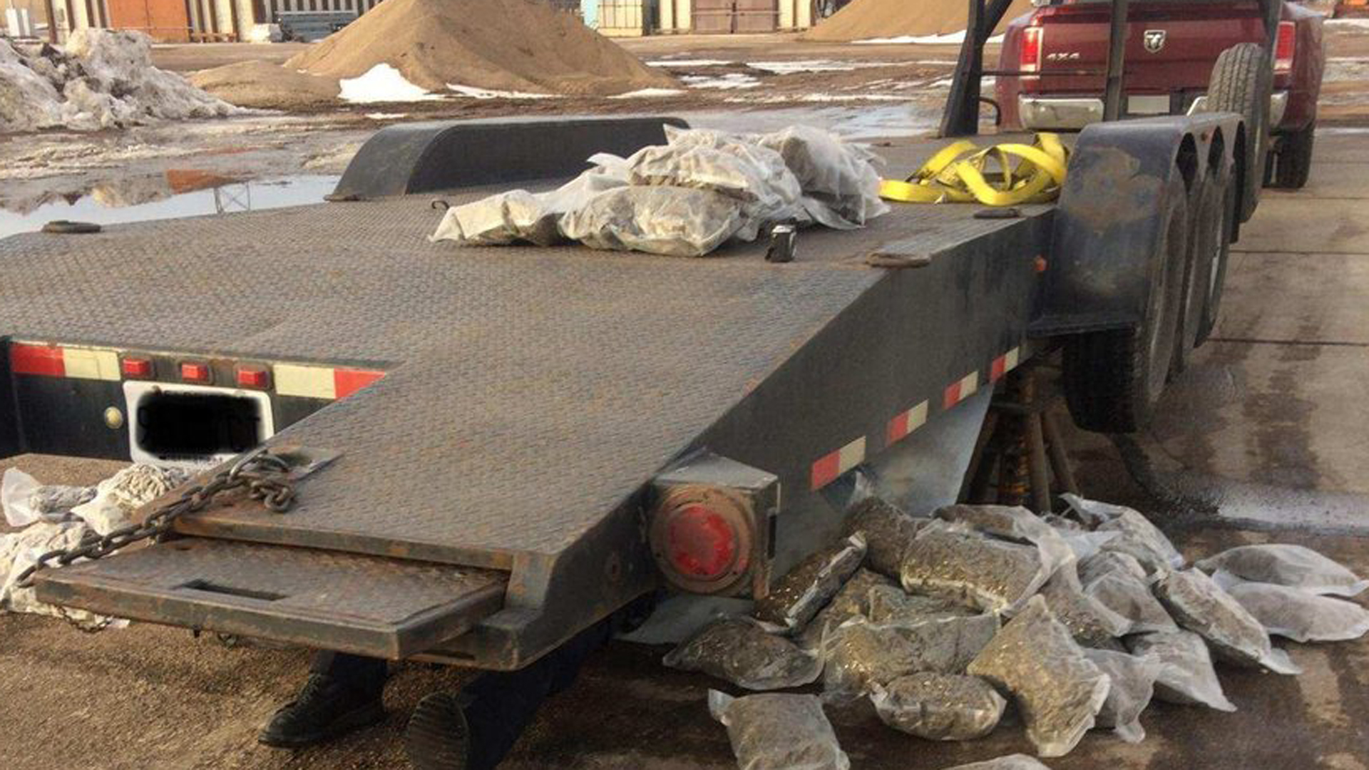 Plastic bags of marijuana are seen on top of a truck's trailer and beside it after Nebraska State Patrol troopers received a call about the drugs falling off the vehicle and onto Interstate 80 near Odessa on Jan. 19, 2018. (Credit: Nebraska State Patrol via Twitter)