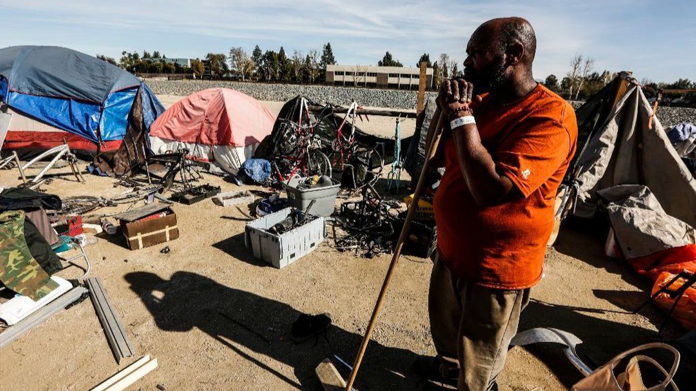 Arthur Johnson looks out toward his belongings on the ground that will need to be cleaned up and stored as Orange County officials started clearing homeless camps in that area of the Santa Ana riverbed on Jan. 22, 2018. (Maria Alejandra Cardona / Los Angeles Times)