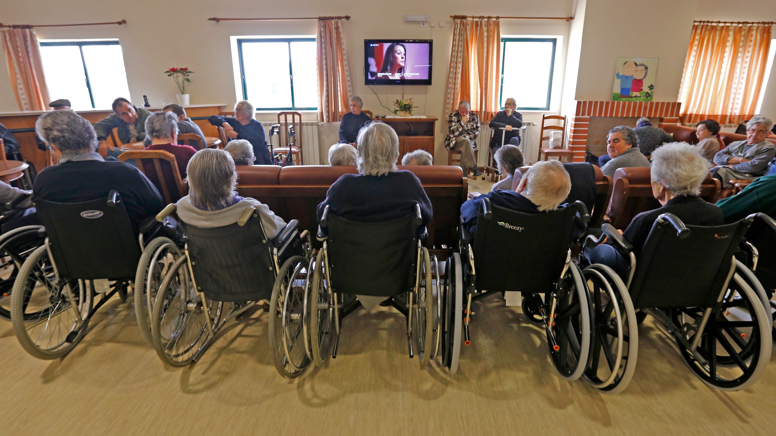 Elderly people watch TV in the living room of nursing home in Alpiarca, Portugal, on Jan. 10, 2016. (Credit: Jose Manuel Ribeiro / AFP / Getty Images)