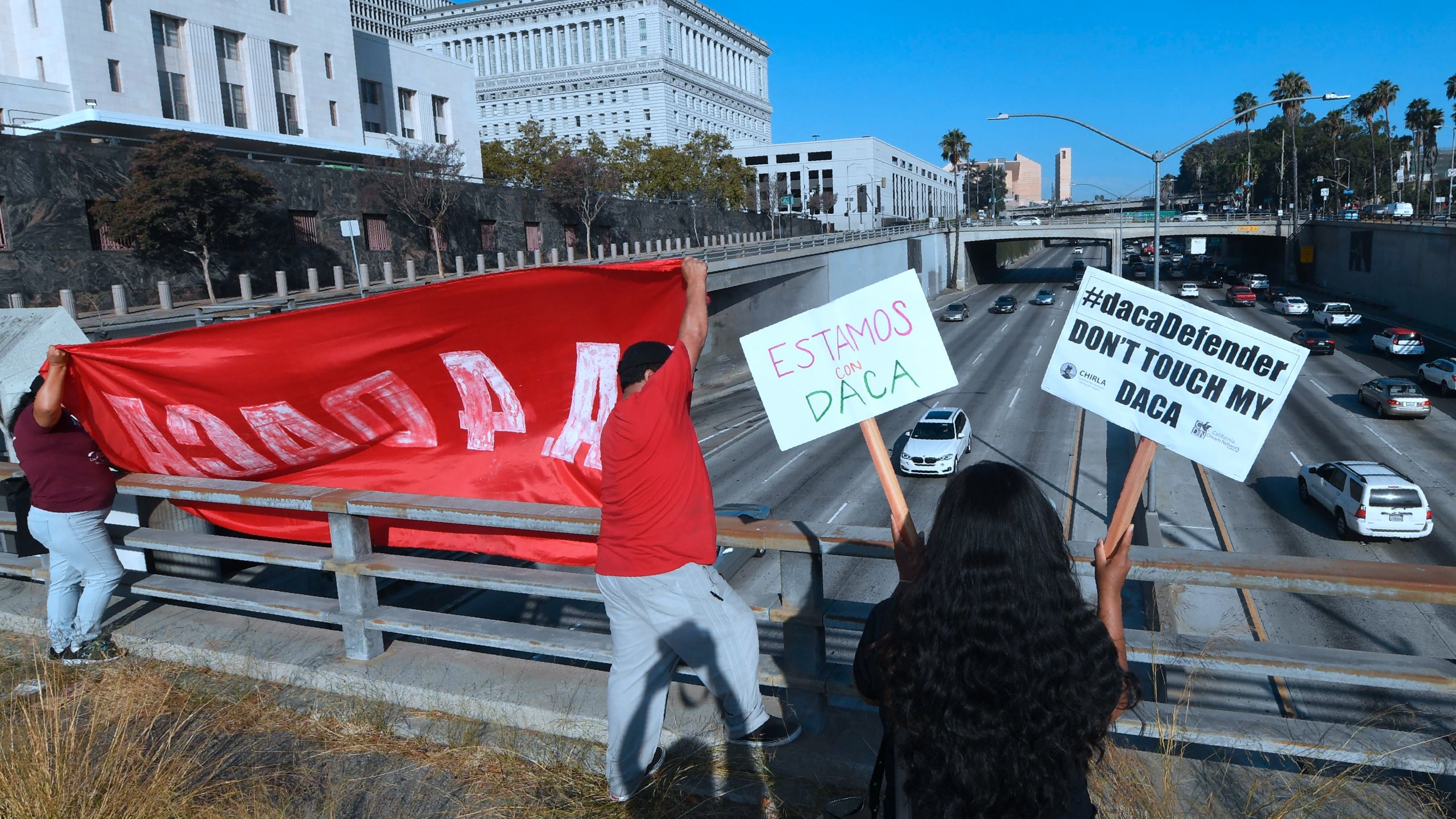 Volunteers from The Coalition for Humane Immigrant Rights (CHIRLA) protest with banners and placards over a freeway in Los Angeles on Aug. 28, 2017. (Credit: FREDERIC J. BROWN/AFP/Getty Images)