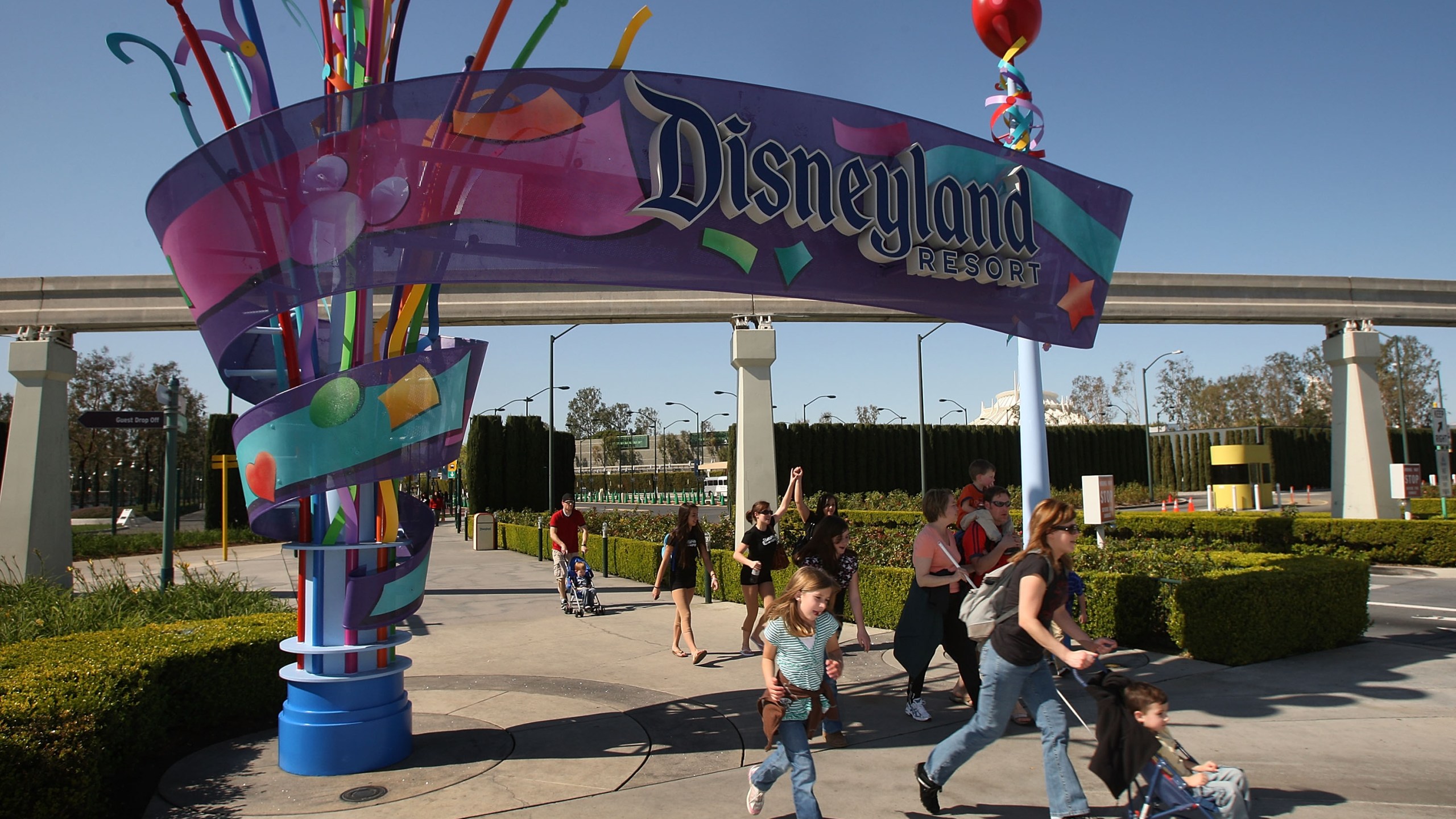 Pedestrians walk near the entrance to Disneyland Resort on Feb. 19, 2009 in Anaheim. (Credit: David McNew/Getty Images)