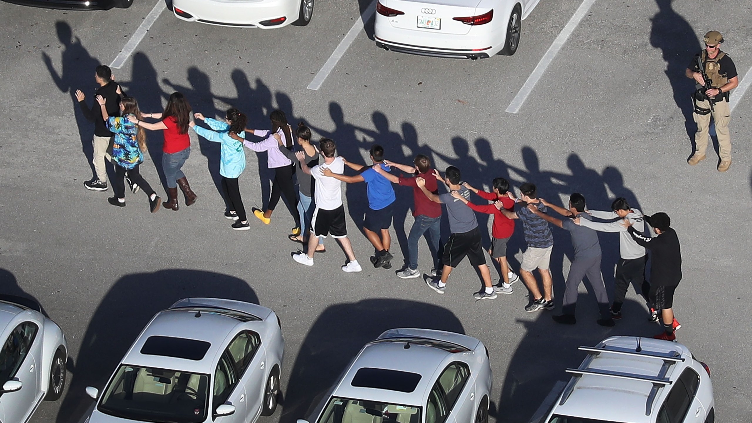 People are brought out of the Marjory Stoneman Douglas High School after a shooting at the school that reportedly killed and injured multiple people on February 14, 2018 in Parkland, Florida. (Credit: Joe Raedle/Getty Images)