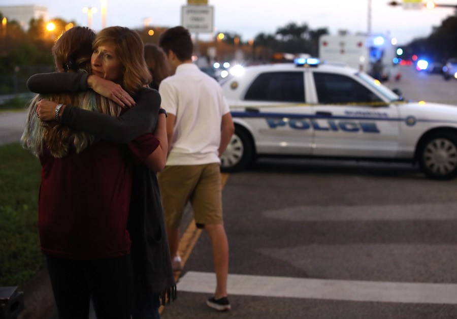 Kristi Gilroy hugs a young woman at a police check point near the Marjory Stoneman Douglas High School on Feb. 15, 2018, in Parkland, Florida. (Credit: Mark Wilson/Getty Images)