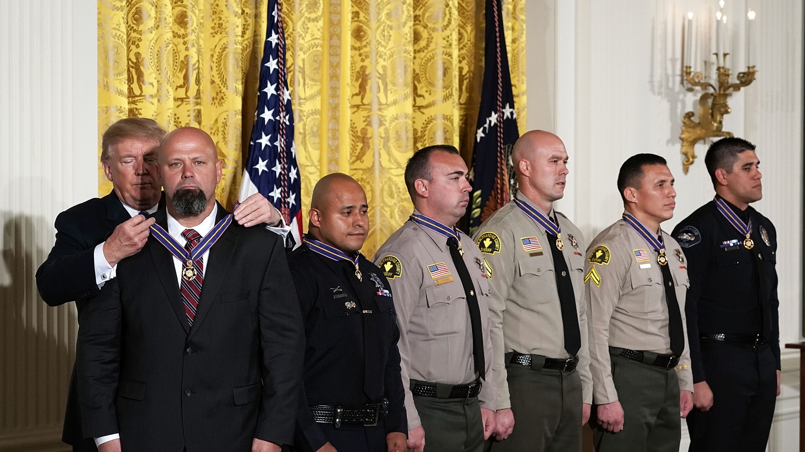 (Left to right) Donald Trump presents the Public Safety Medal of Valor to San Bernardino County District Attorney's Office Investigator Chad Johnson, San Bernardino Police Department Detective Brian Olvera, San Bernardino County Sheriff's Department Deputy Shaun Wallen, Detective Bruce Southworth, Corporal Rafael Ixco and Redlands Police Department Officer Nicholas Koahou during an award ceremony at the East Room of the White House on Feb. 20, 2018 in Washington, DC. (Credit: Alex Wong/Getty Images)